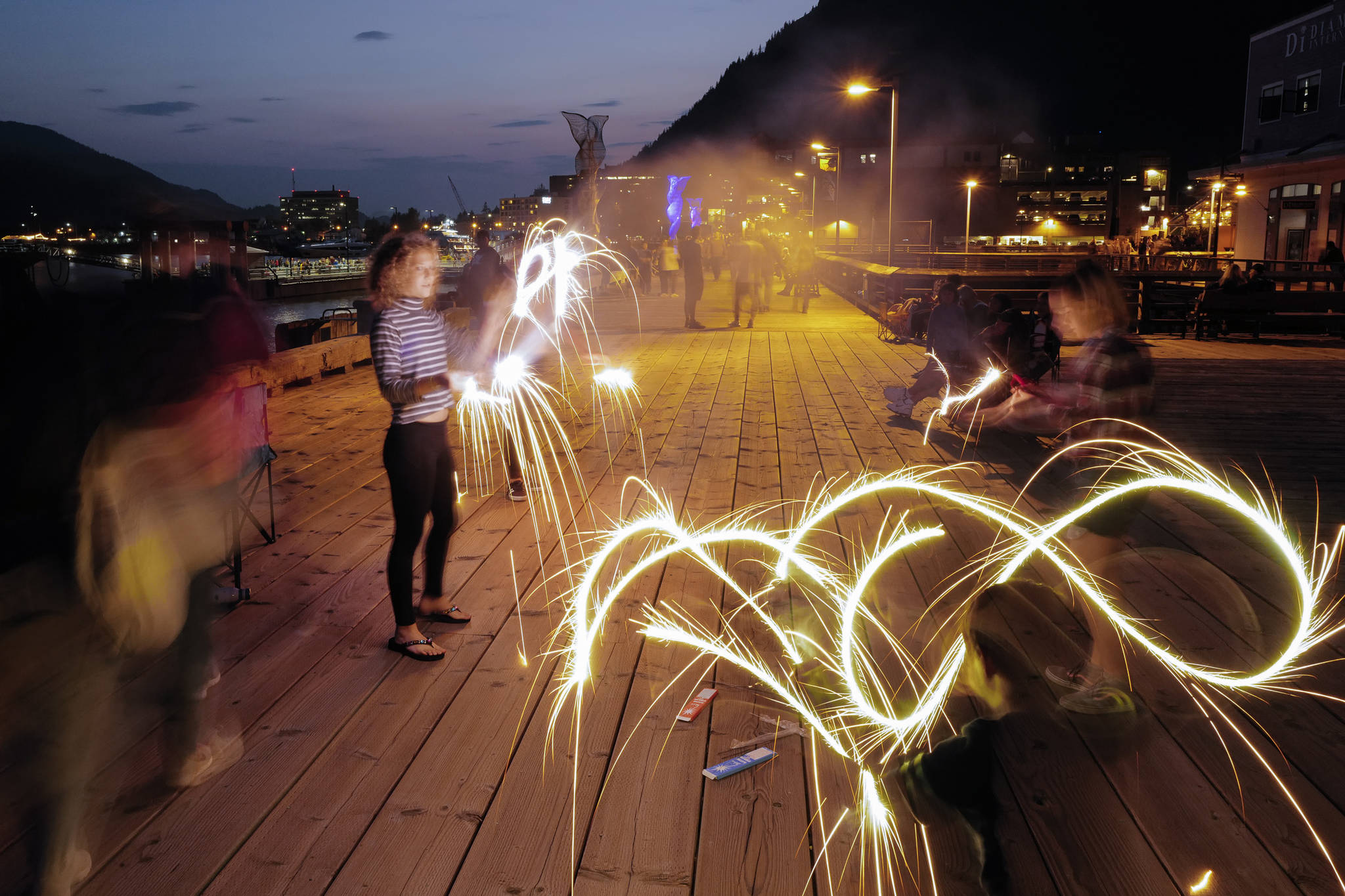 Children play with sparklers as Juneau residents gather along the downtown waterfront to watch the annual fireworks display on Wednesday, July 3, 2019. (Michael Penn | Juneau Empire)