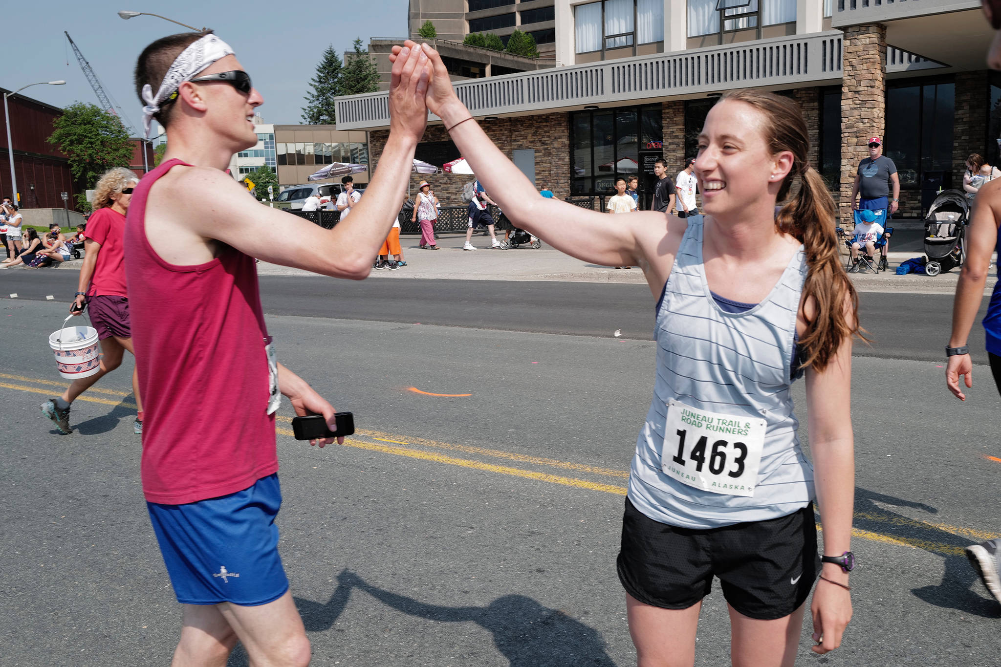 Beth Gollin, right, receives a high five from Drew Stafford after she was the first woman to finish the Glenn Frick Memorial Mile on Thursday, July 4, 2019. (Michael Penn | Juneau Empire)
