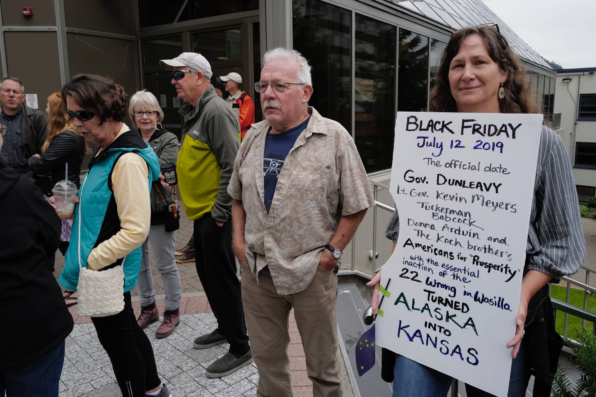 Sarah Dunlap holds her “Black Friday” sign at a rally against Gov. Mike Dunleavy’s budget vetoes in front of the Capitol on Friday, July 12, 2019. (Michael Penn | Juneau Empire)