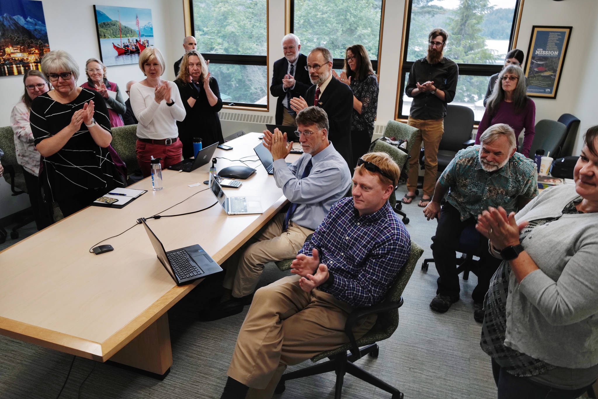 University of Alaska Southeast administrators and staff applaud a speech by Sen. Click Bishop, R-Fairbanks, as they watch an online meeting being held at UA campuses around the state on Gov. Mike Dunleavy’s budget cuts on Monday, July 15, 2019. (Michael Penn | Juneau Empire)