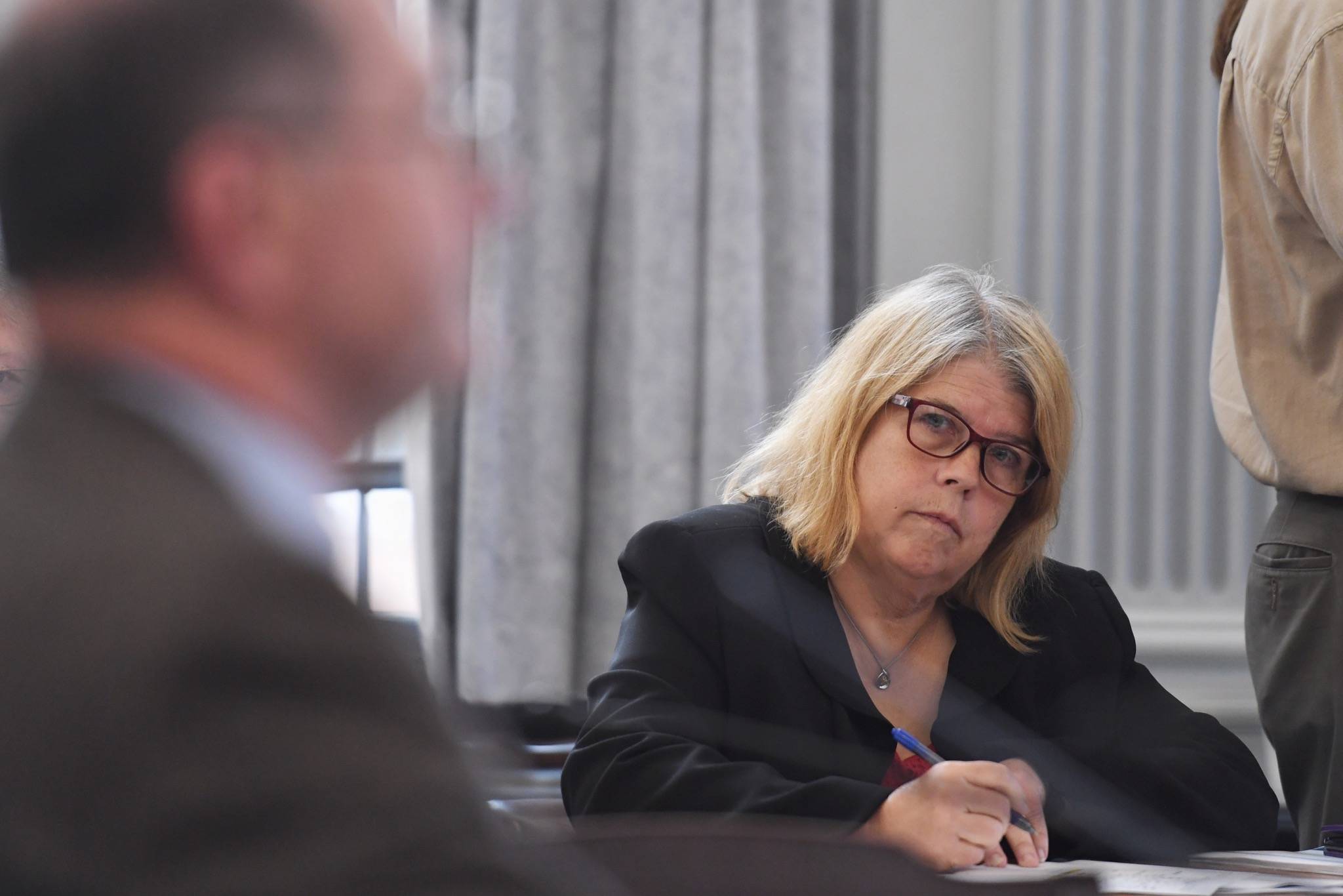Rep. Tammie Wilson, R-North Pole, listens to David Teal, director of Legislative Finance, as he explains budget shortfalls to the Senate Finance Committee at the Capitol on Friday, July 19, 2019. (Michael Penn | Juneau Empire)