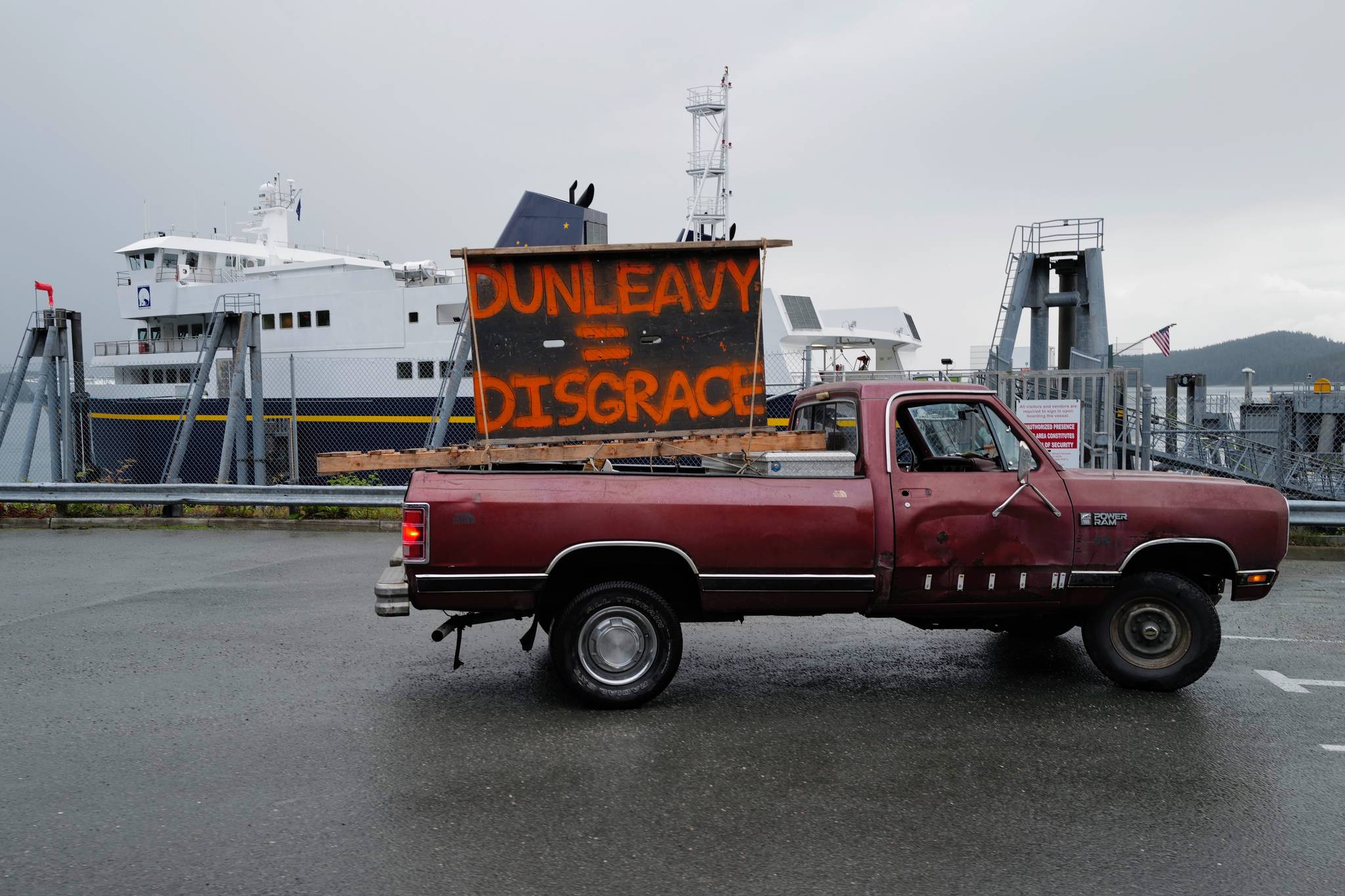 Mike Forrest, a local supporter of ferry system, drives his truck with signs at the Auke Bay Terminal on Wednesday, July 24, 2019. (Michael Penn | Juneau Empire)