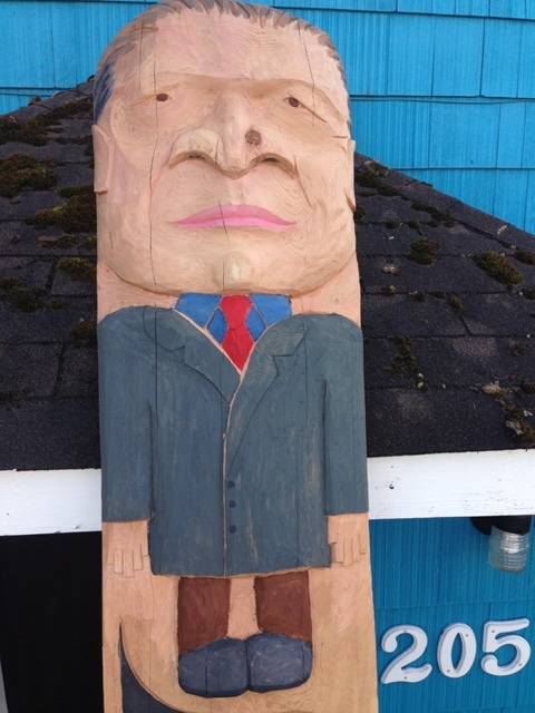 Gov. Mike Dunleavy stands at the top of Tlingit master carver Tommy Joseph’s shame pole, which also depicts President Donald Trump. (Courtesy Photo | Kristina Cranston)