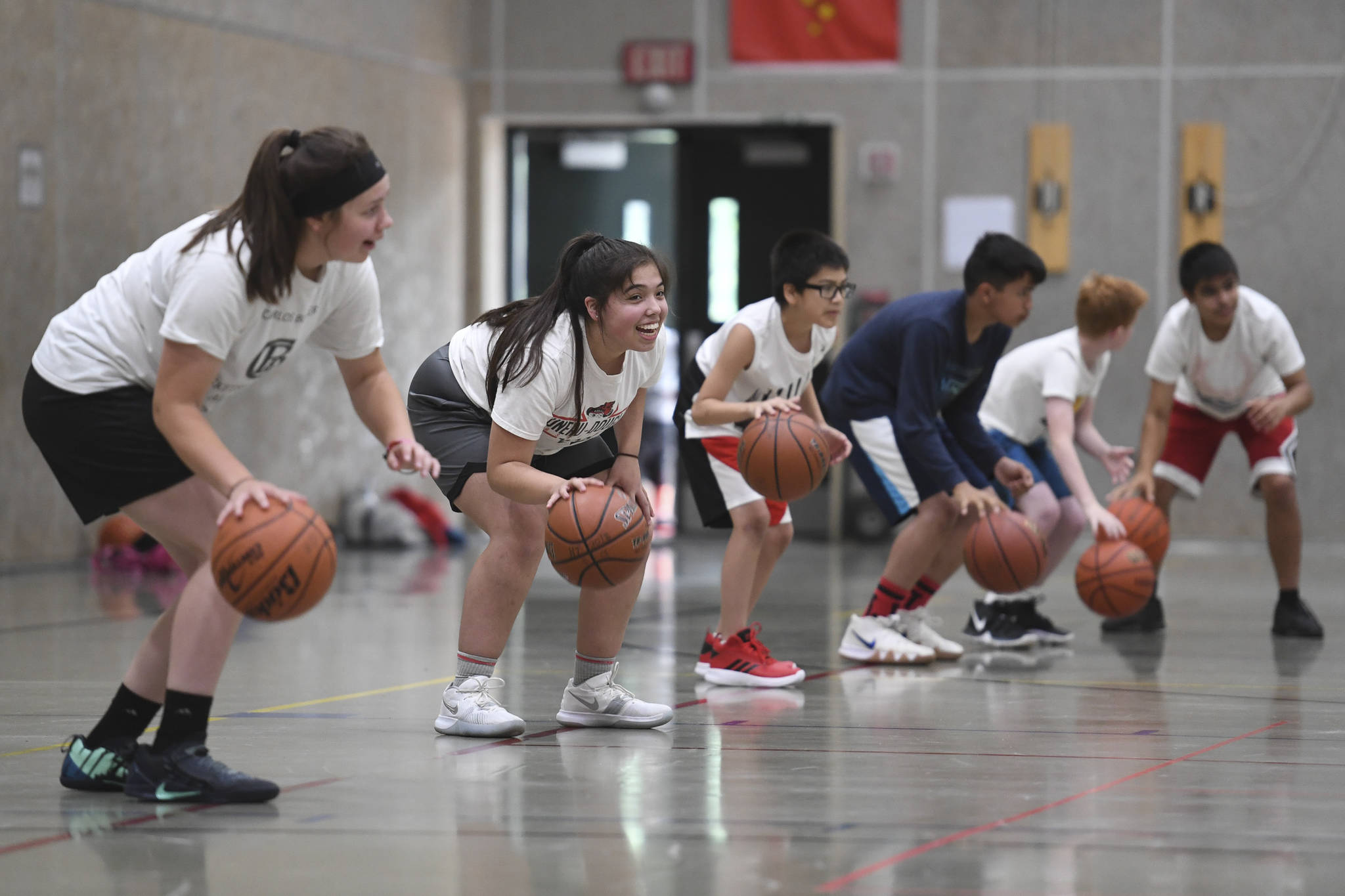 Students practice dribbling during the Latseen Hoop Camp at Dzantak’i Heeni Middle School on Monday, July 29, 2019. The camp runs all week for students entering grades 6-12. (Michael Penn | Juneau Empire)