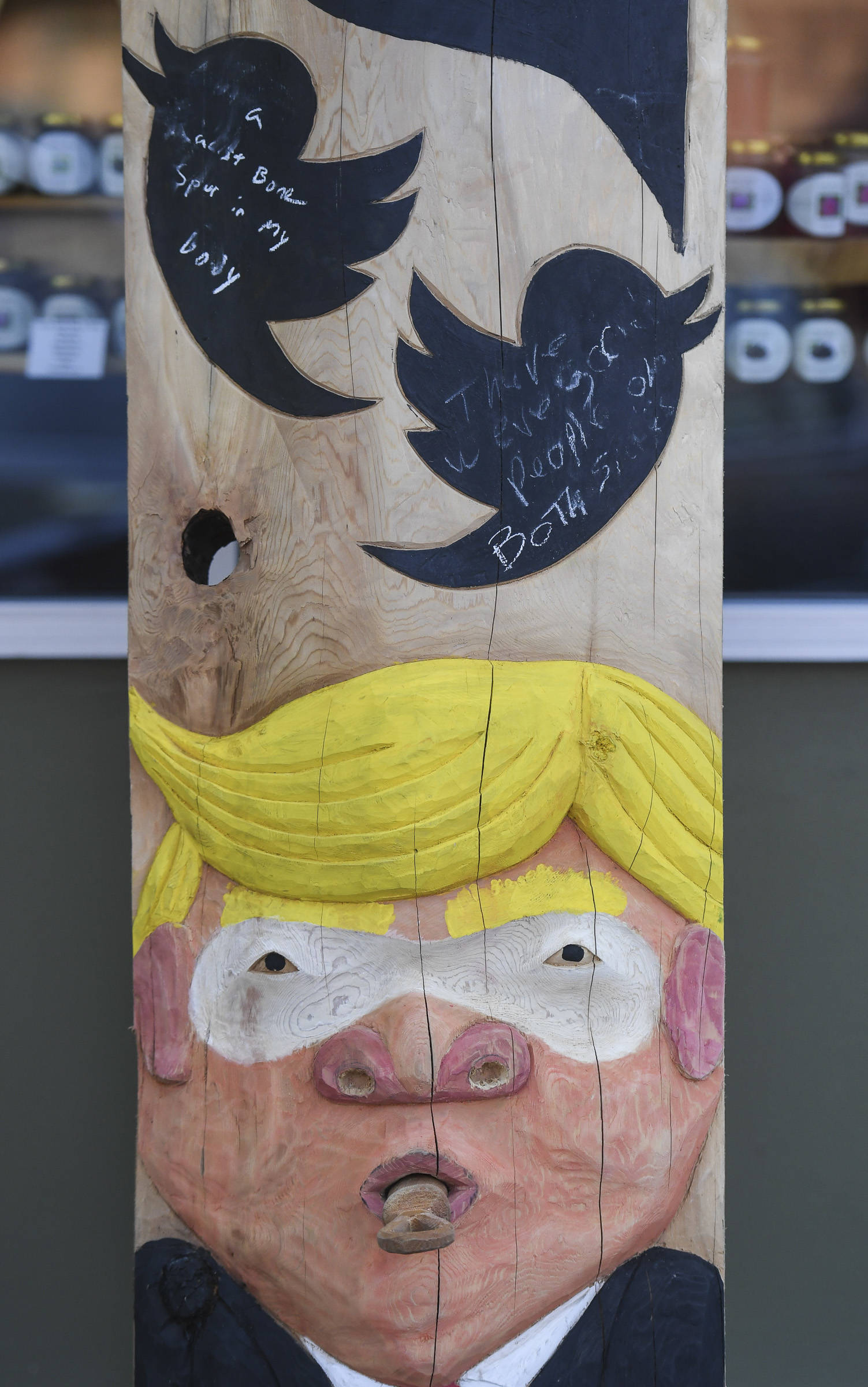 A ridicule pole carved by Sitka artist Tommy Joseph stands in front of the Planet Alaska Gallery on Ferry Way on Wednesday, July 31, 2019. The pole includes likenesses of President Donald Trump, shown, and Alaska Gov. Mike Dunleavy. (Michael Penn | Juneau Empire)