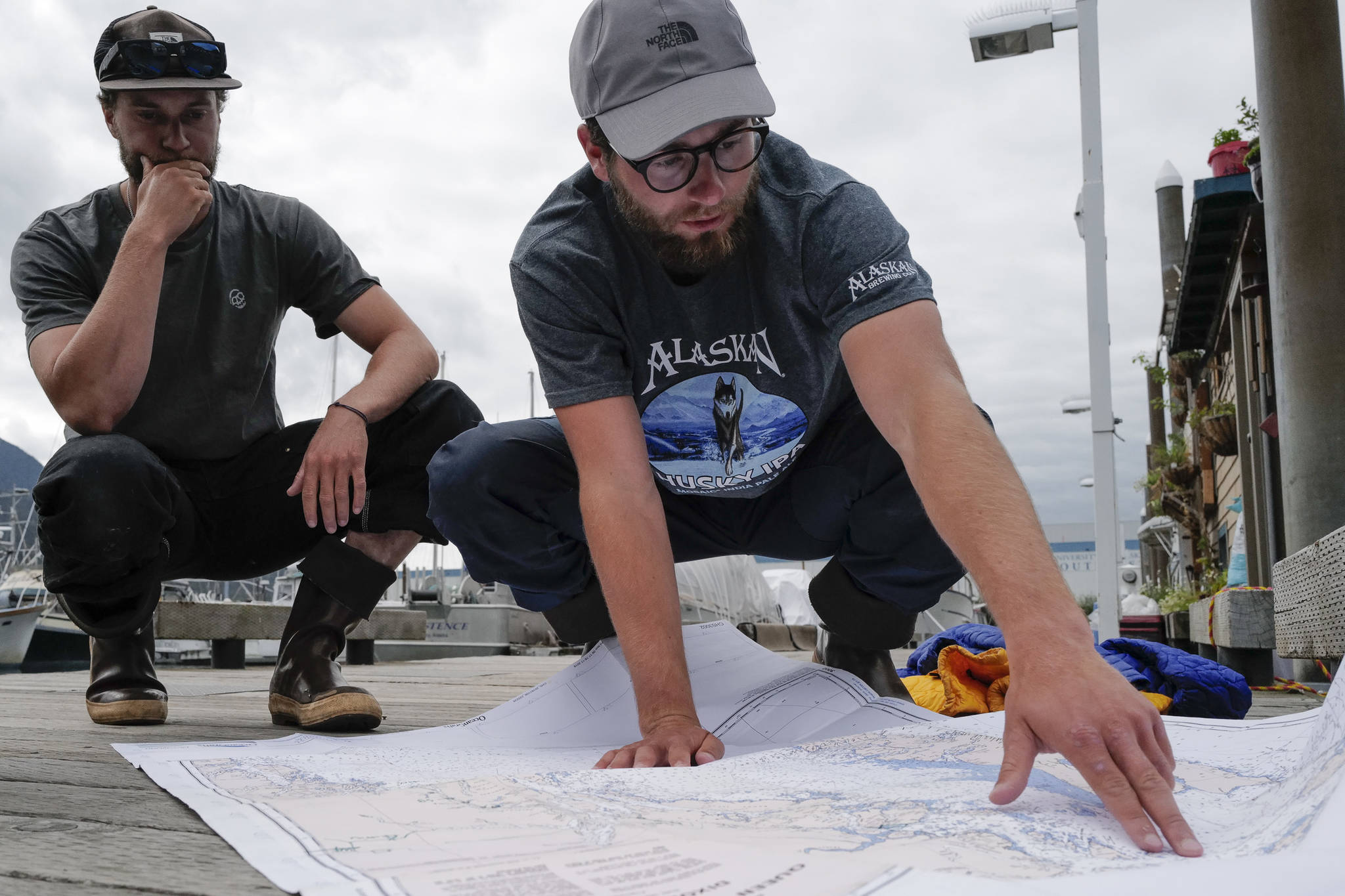 Liam Godfrey-Jolicoeur, left, and Jake Dombek, talk at Harris Harbor on Thursday, Aug. 2, 2019, about their nearly two-month long trip up the Inside Passage by canoe. Both are orginally from Vermont used the trip to raise money and bring awareness to environmental causes. (Michael Penn | Juneau Empire)
