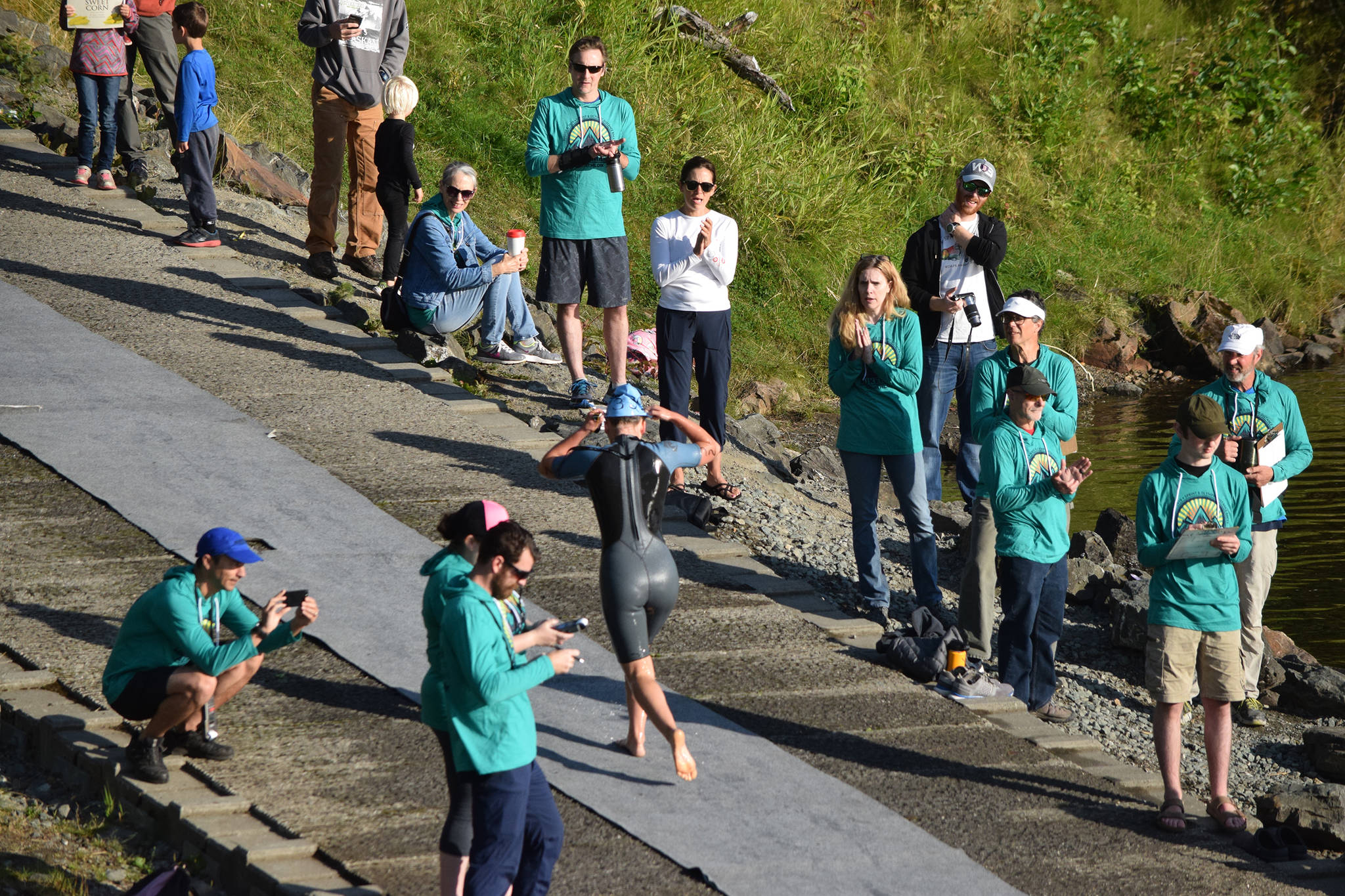 Aukeman Triathlon supporters cheer on a swimmer as they leave Auke Lake on Saturday, Aug. 3, 2019. (Nolin Ainsworth | Juneau Empire)