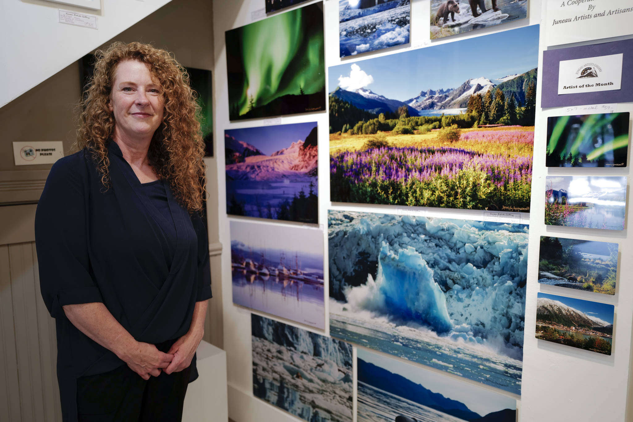 Merridy Magnussson shows off her photography as the featured artist at the Juneau Artist’s Gallery during First Friday on Friday, Aug. 2, 2019. (Michael Penn | Juneau Empire)