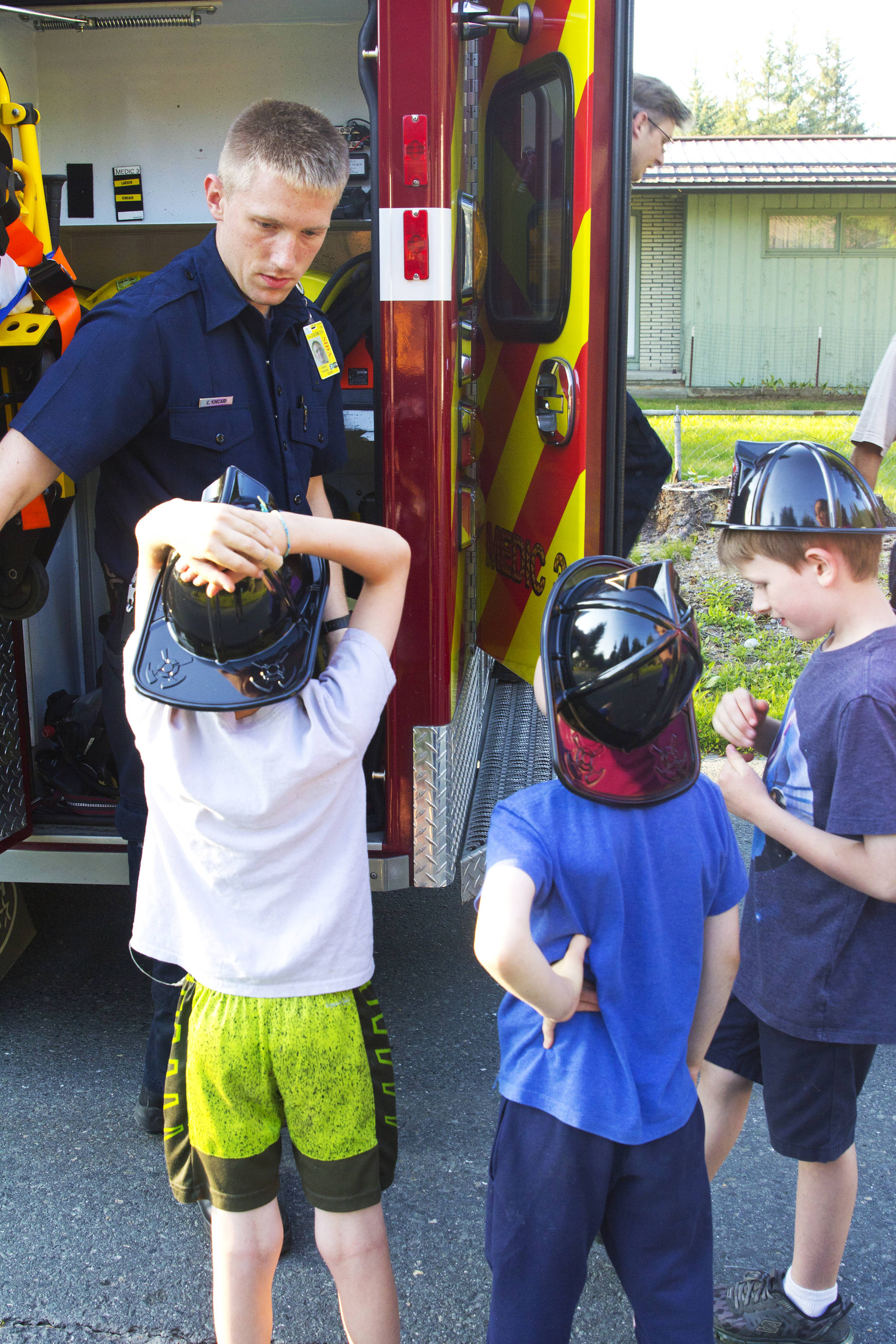 Conor Kincaid, firefighter/EMT with Capital City Fire/Rescue, explains his job to some local children during the National Night Out, Aug. 6, 2019. (Michael S. Lockett | Juneau Empire)