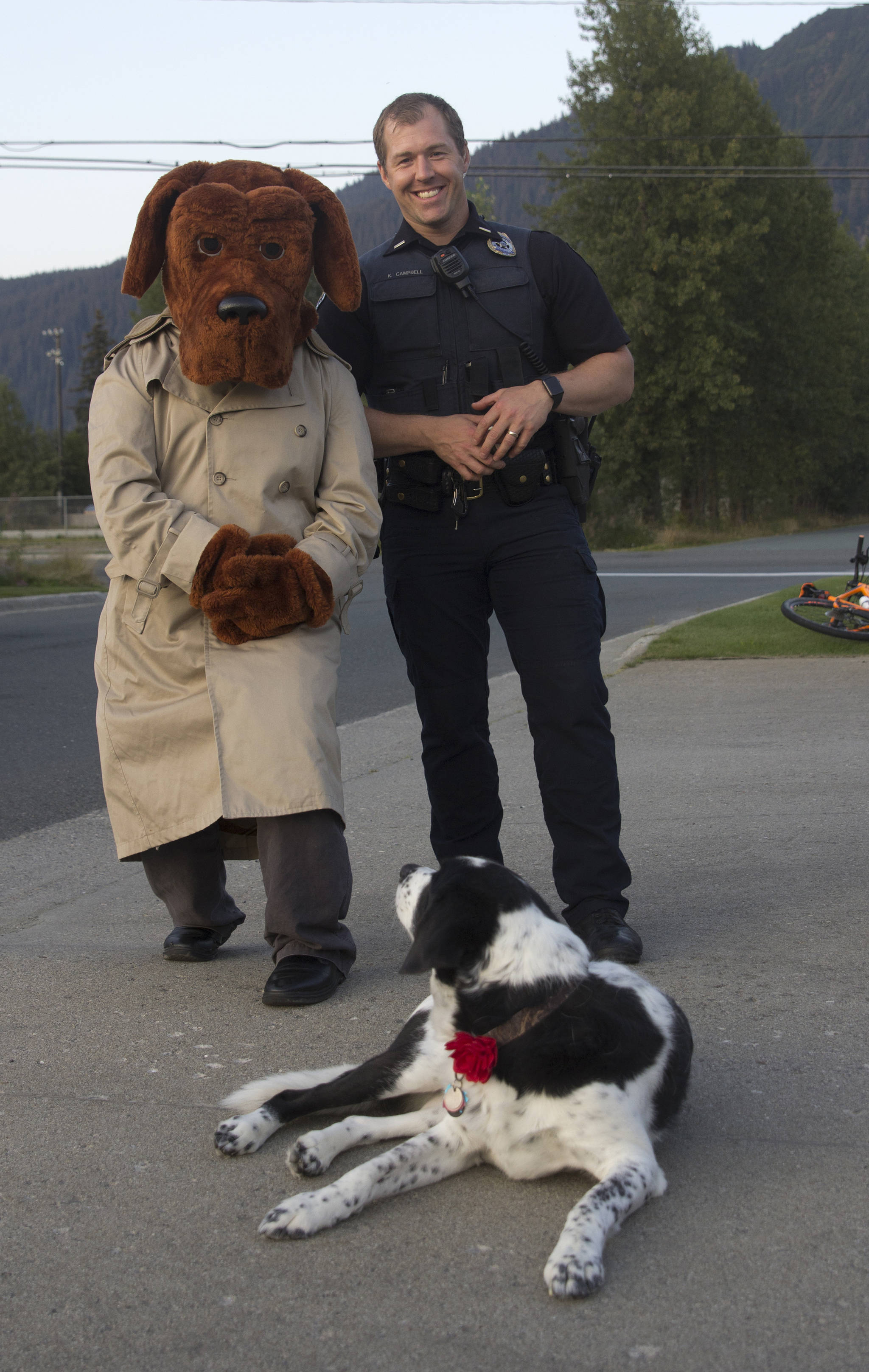 Lt. Krag Campbell, patrol lieutenant with Juneau Police Department, and McGruff the Crime Dog, pose with Delta, a somewhat confused neighborhood resident during the National Night Out, Aug. 6. (Michael S. Lockett | Juneau Empire)