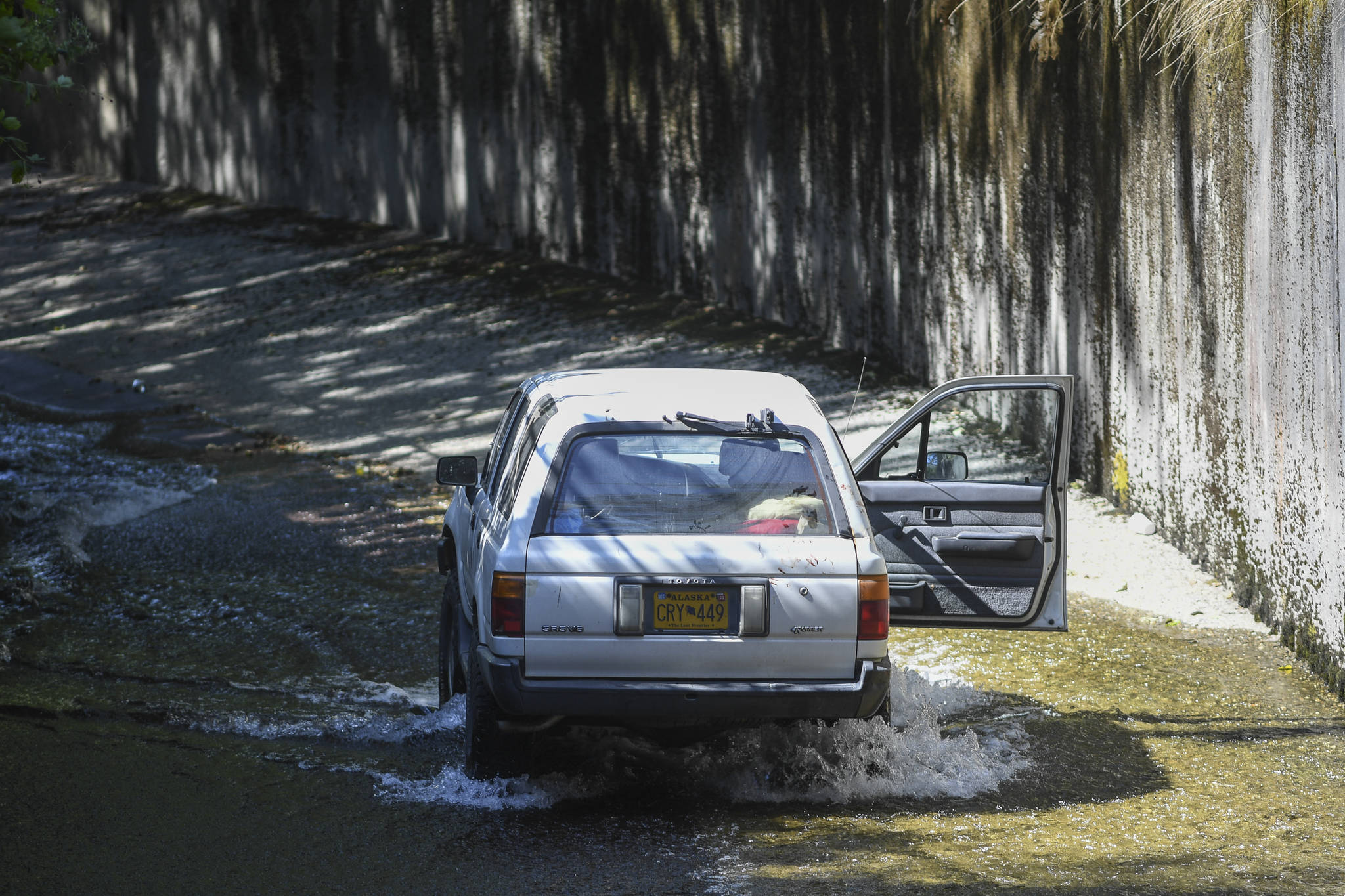 A Toyota 4Runner sits in Gold Creek on Friday, Aug. 9, 2019, after it went through a fence and over the cement embankment. (Michael Penn | Juneau Empire)