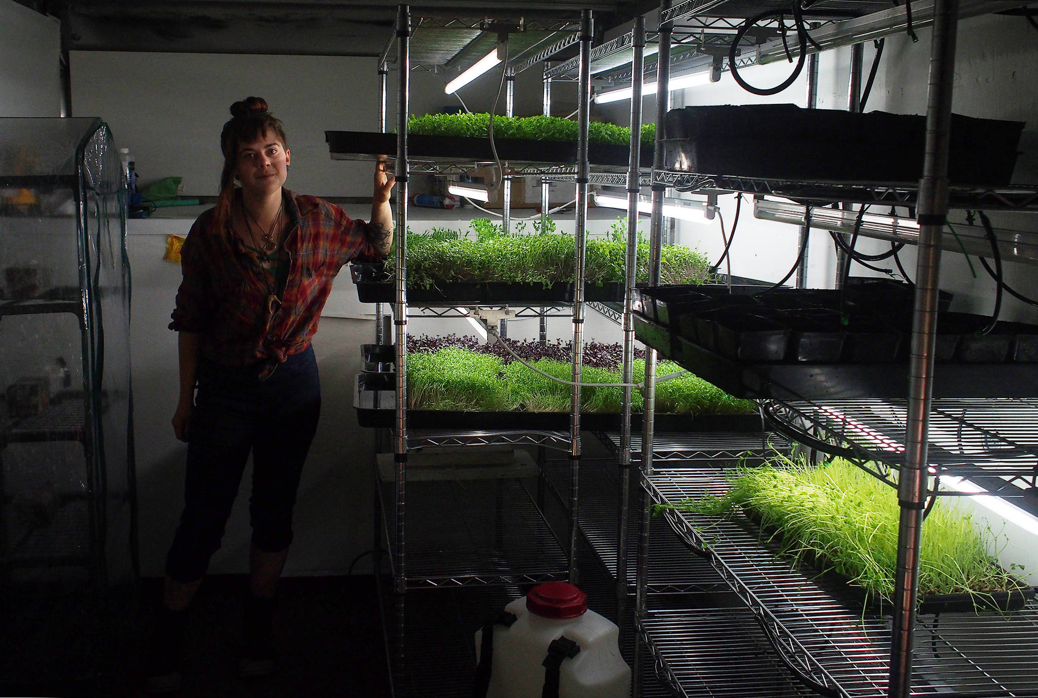 “The Farm” owner Duras Ruggles poses next to trays of microgreens in the back of a moving truck she’s outfitting with growing equipment. (Nolin Ainsworth | Juneau Empire)