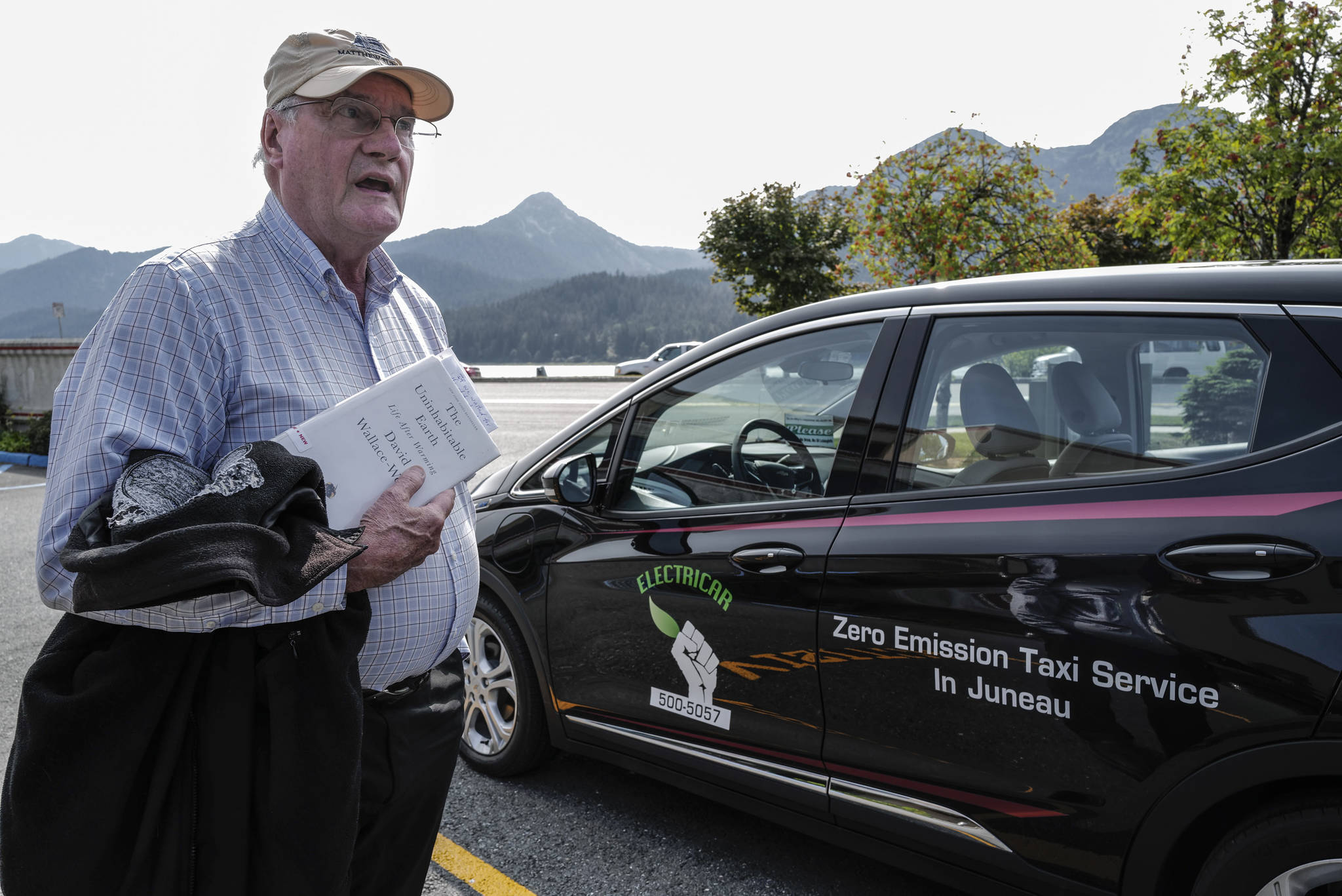 Mike Orford stands next to his brand new 2019 Chevy Bolt Electric Vehicle on Monday, Aug. 12, 2019. Orford, who has been a taxi driver for EverGreen Taxi, plans to put into zero emission vehicle into service to reduce costs and lead the way for a more sustainable way of life. (MIchael Penn | Juneau Empire)