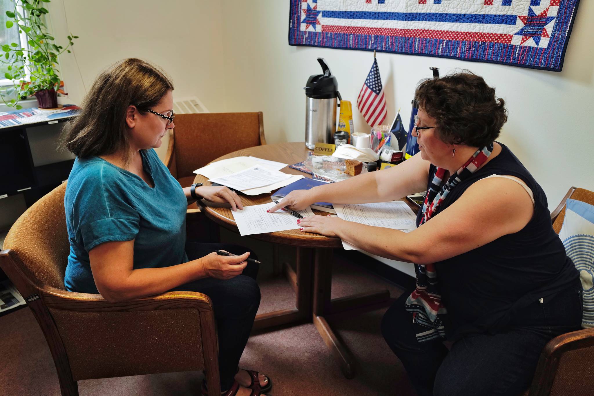 Amanda Ryder, left, signs her application for Municipal Clerk Beth McEwen on Monday, Aug. 12, 2019, to run for one of two open school board seats in this falls municipal election. (Michael Penn | Juneau Empire)