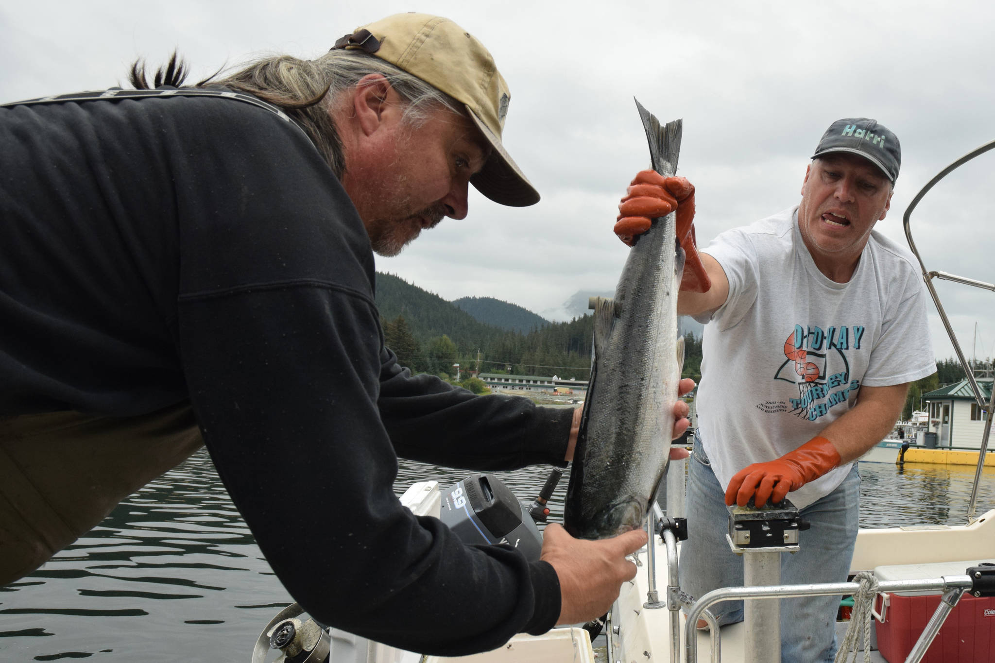 In this Aug. 16, 2015 photo, Craig Kahklen hands a silver salmon scholarship fish to Rosco Palmer at Don D. Statter Memorial Boat Harbor in Auke Bay on the final day of the Golden North Salmon Derby. (Michael Penn | Juneau Empire File)