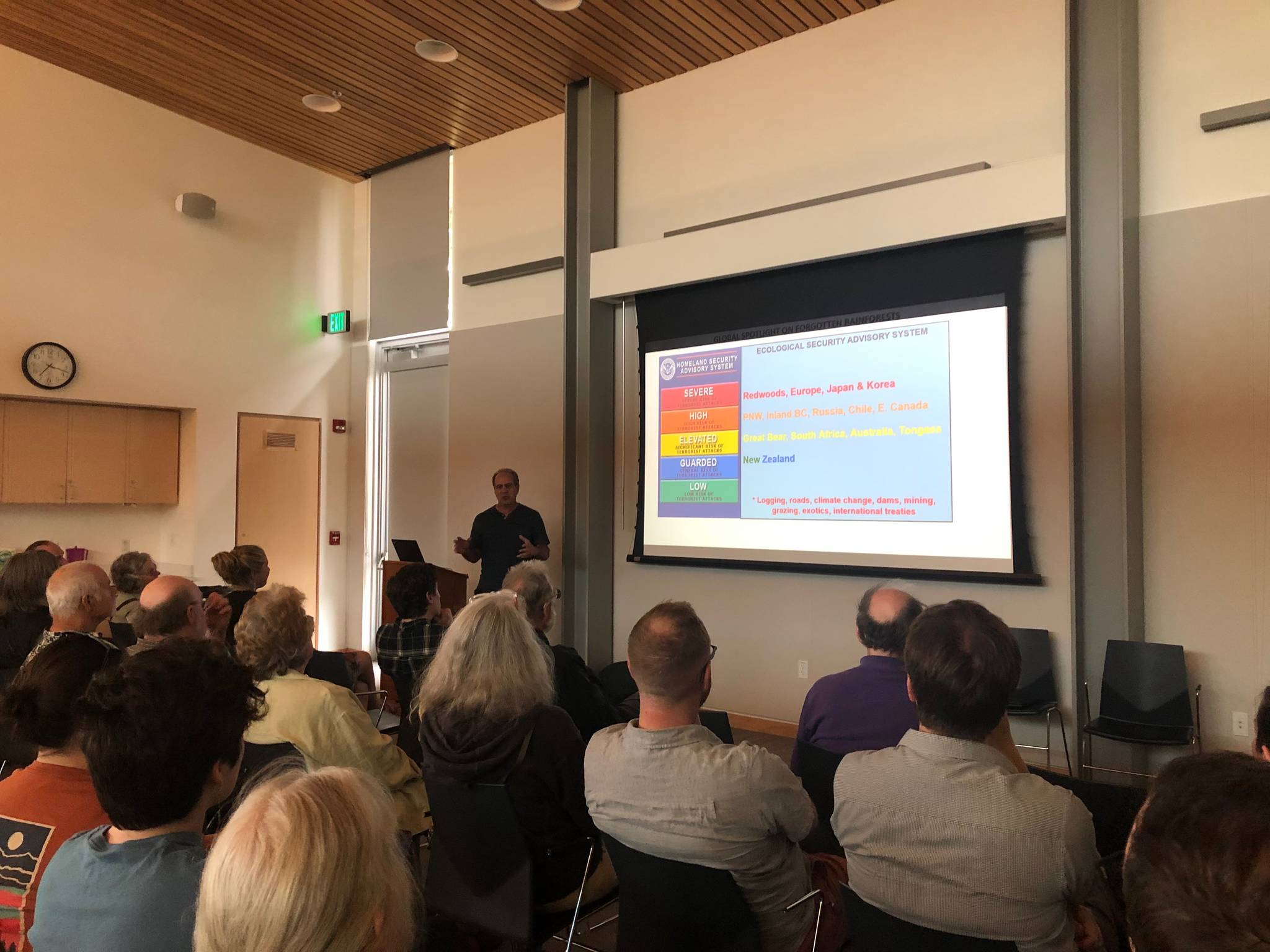Dominick DellaSala, Ph.D. shows a slide depicting a warning level rating he created for forests based off the Transportation Security Administration’s rating system used at airports on Aug. 13, 2019. (Peter Segall | Juneau Empire)