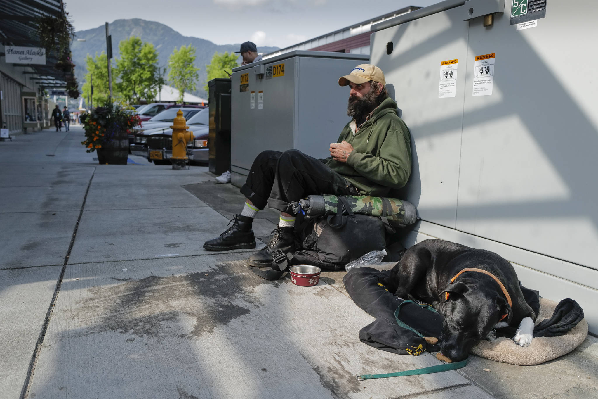 Woody MacAllister hangs out on Franklin Street at Ferry Way with his dog, Rainy, on Tuesday, Aug. 13, 2019. McAllister said he doesn’t stay at the Glory Hall, Juneau’s emergency shelter and soup kitchen, but does eat there. The shelter is closing their doors from 7 a.m. to 2 p.m. daily due to budget cuts forcing their homeless clients to find other places to be. Oatmeal and coffee were available to clients before leaving the shelter but no lunch is available. (Michael Penn | Juneau Empire)