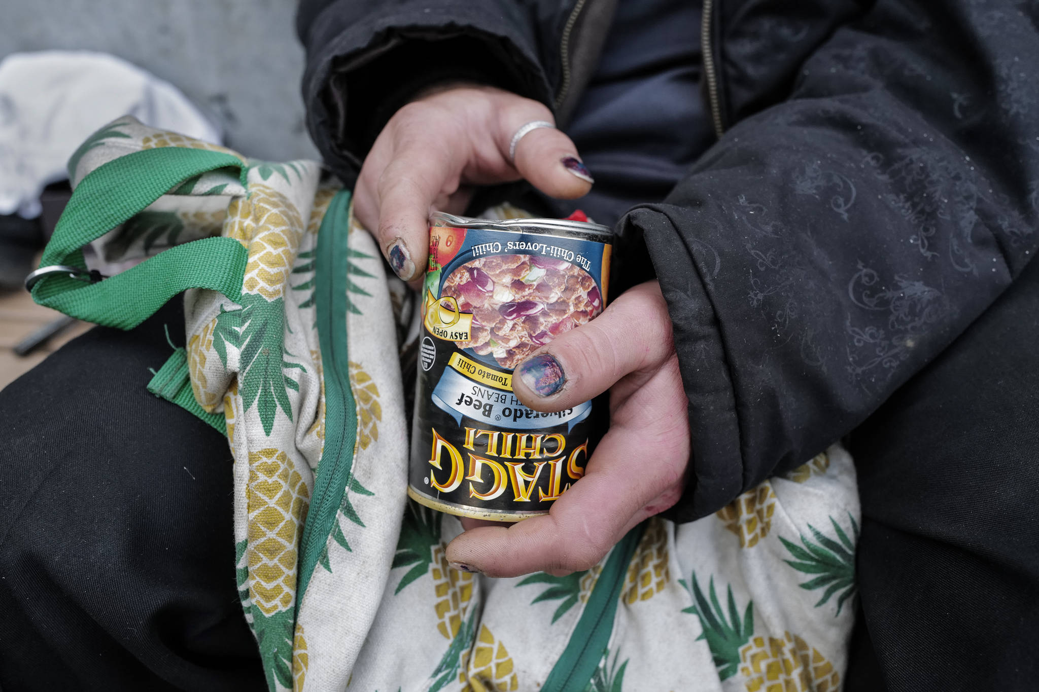 Justin Fairclough, who said he has stayed on and off at the Glory Hall over the last four years, holds a can of chili in front of the Juneau Downtown Library on Tuesday, Aug. 13, 2019. Fairclough said he had no way of heating the food for lunch. (Michael Penn | Juneau Empire)
