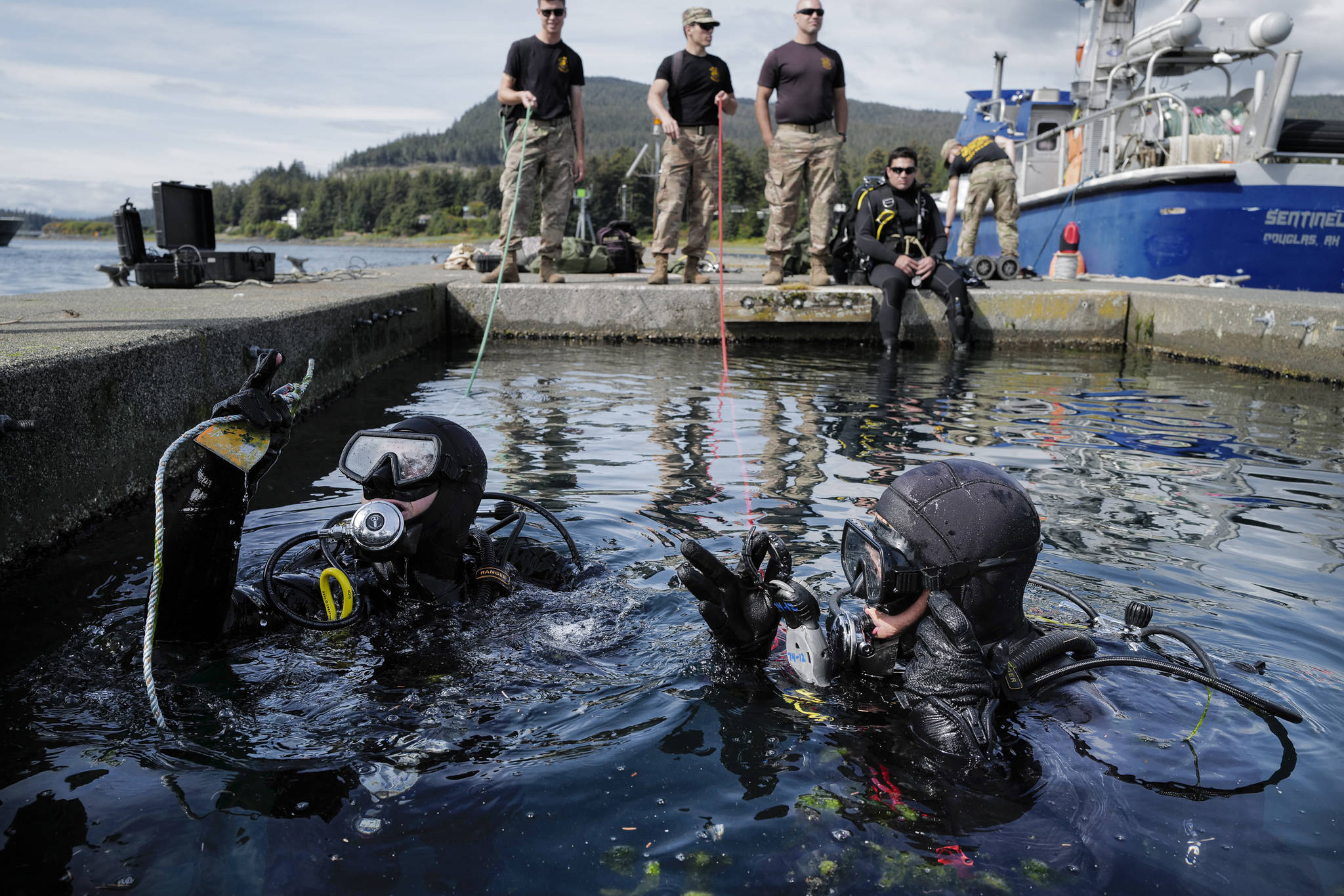 Sgt. Cesar Rodriquez, left, and Sgt. Kenneth Byrd, of the U.S. Army’s 74th Engineer Dive Detachment check their gauges one last time before submerging on a project at the Don D. Statter Boat Harbor in Auke Bay on Friday, Aug. 16, 2019. Members of the U.S. Army’s 74th Engineer Dive Detachment and U.S. Coast Guard Regional Dive Locker West worked together to inspect and replace the bolts holding the harbor’s breakwater together. (Michael Penn | Juneau Empire)
