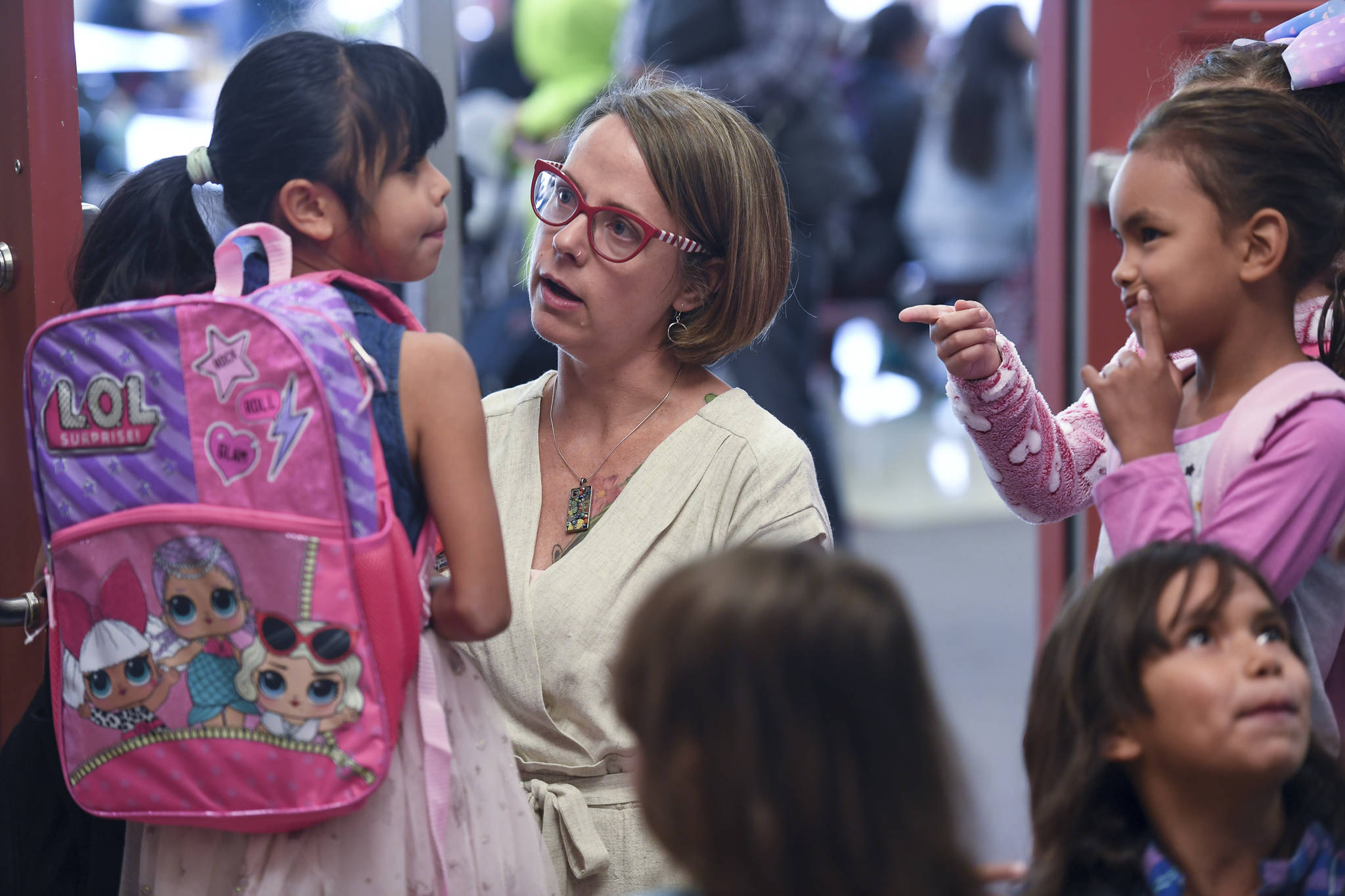 Elizabeth Pisel-Davis, Principal of Riverbend Elementary School, helps students arriving for the first day of school on Monday, Aug. 19, 2019. (Michael Penn | Juneau Empire)