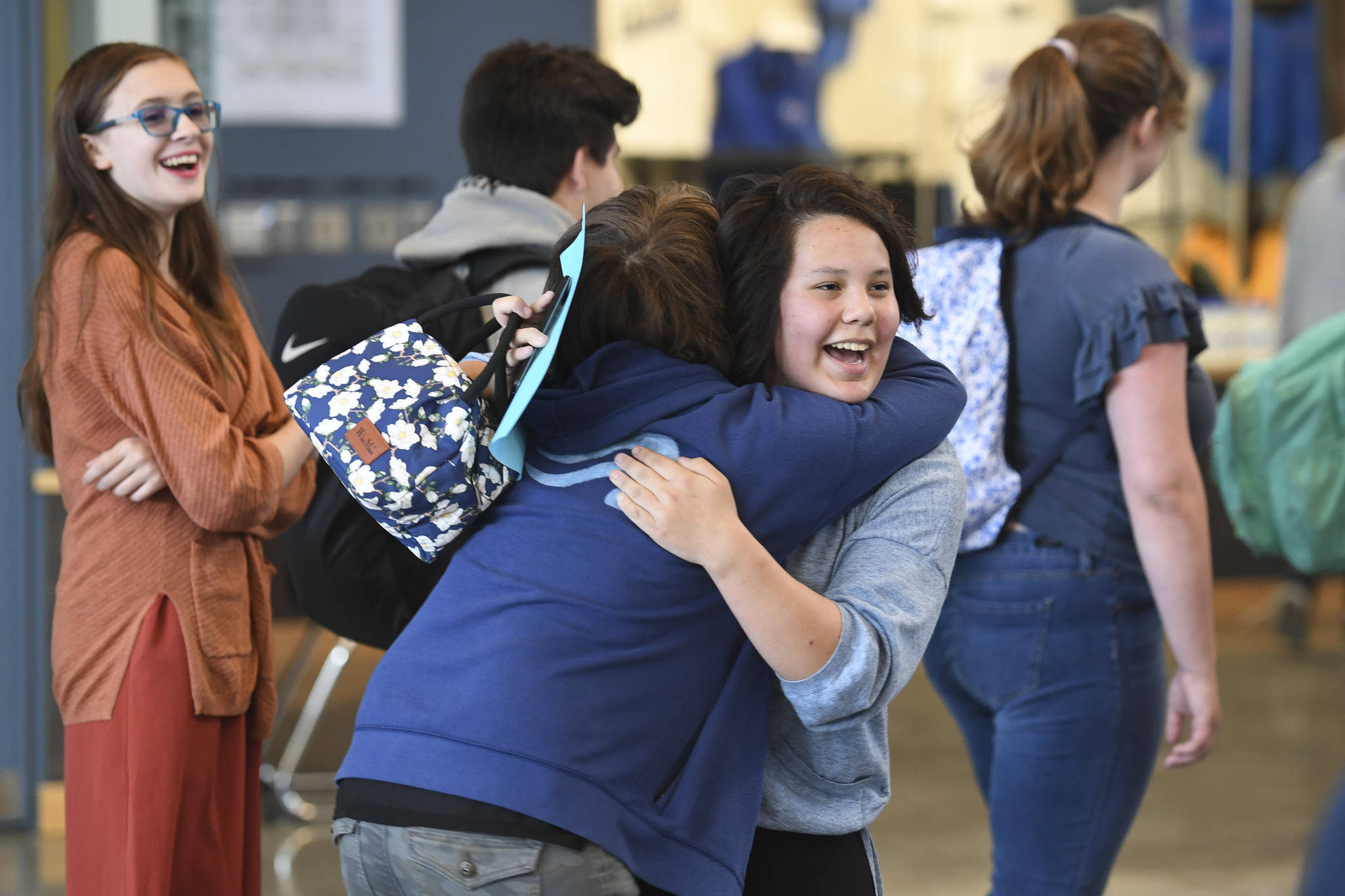 Freshman Jetta Hosiner, right, and Freshman Taren Wright hug as Freshman Kelsi Sell, left, looks on after arriving for the first day of school at Thunder Mountain High School on Monday, Aug. 19, 2019. (Michael Penn | Juneau Empire)