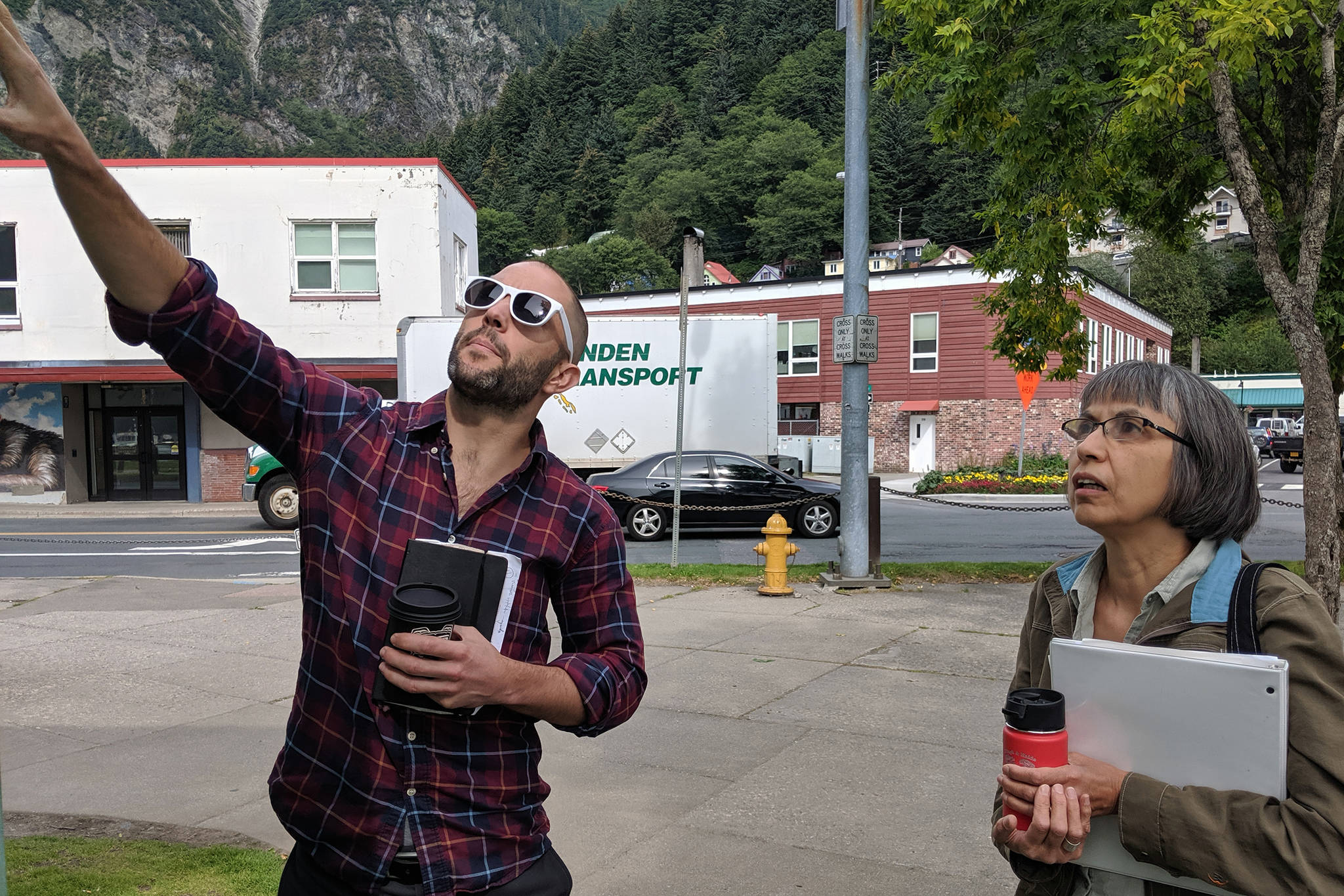 Co-artistic collaborator and facilitators for Ryan Conarro and Lillian Petershoare Juneau Voices Audio Wayfinding Project point to existing signage Tuesday, Aug. 20, 2019. The sign will be replaced by one linked to an audio installation in spring or summer of next year. (Ben Hohenstatt | Juneau Empire)