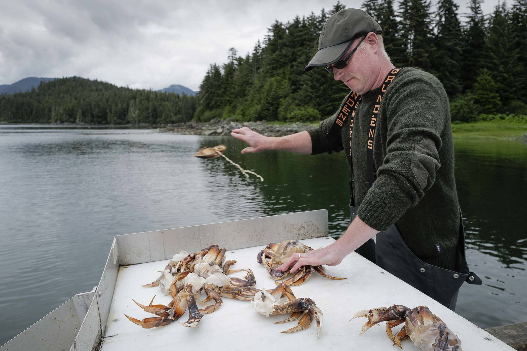Todd Brocious cleans his crab catch at the Amalga Harbor boat launch on Wednesday, June 19, 2019. (Michael Penn | Juneau Empire)