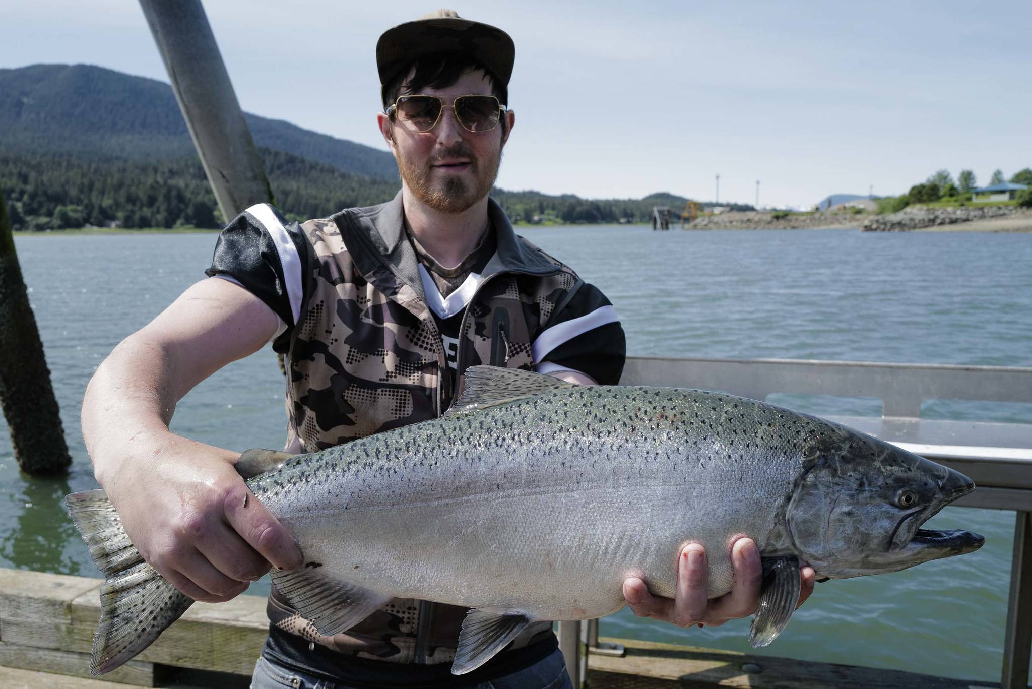 Alexander Masters displays his freshly caught king salmon at the Wayside Park on Channel Drive on Thursday, June 20, 2019. (Michael Penn | Juneau Empire)