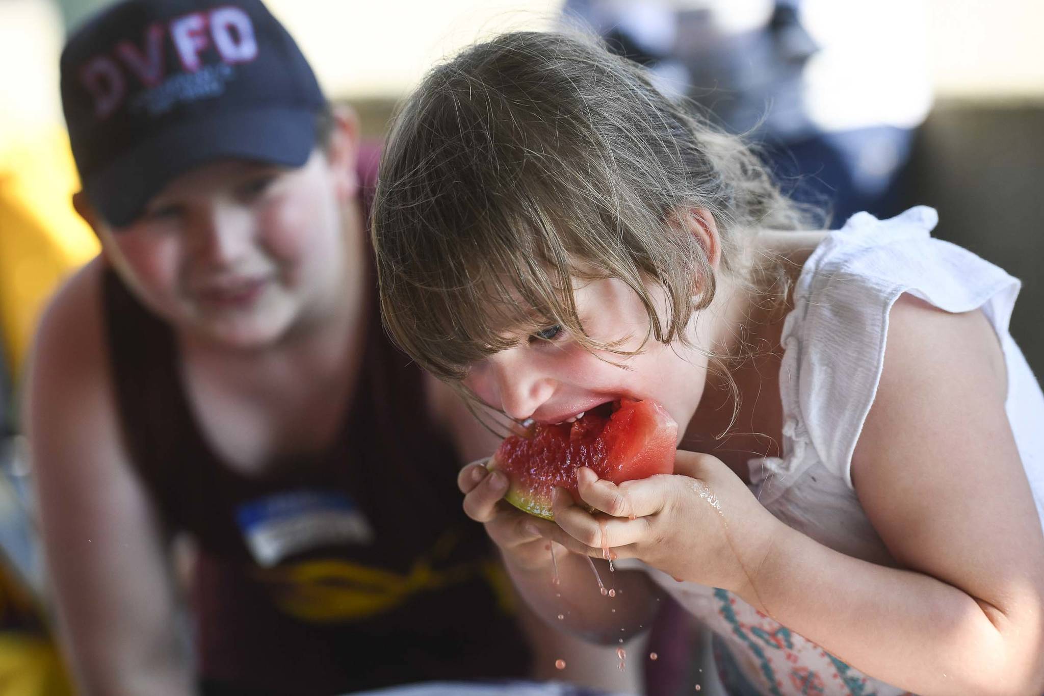 Joseph Race, 8, left, cheers on his sister, Lyllianna, 5, in a watermelon eating contest during a community picnic sponsored by the Douglas Fourth of July Committee and Capital City Fire/Rescue at Sandy Beach on Wednesday, July 3, 2019. (Michael Penn | Juneau Empire)