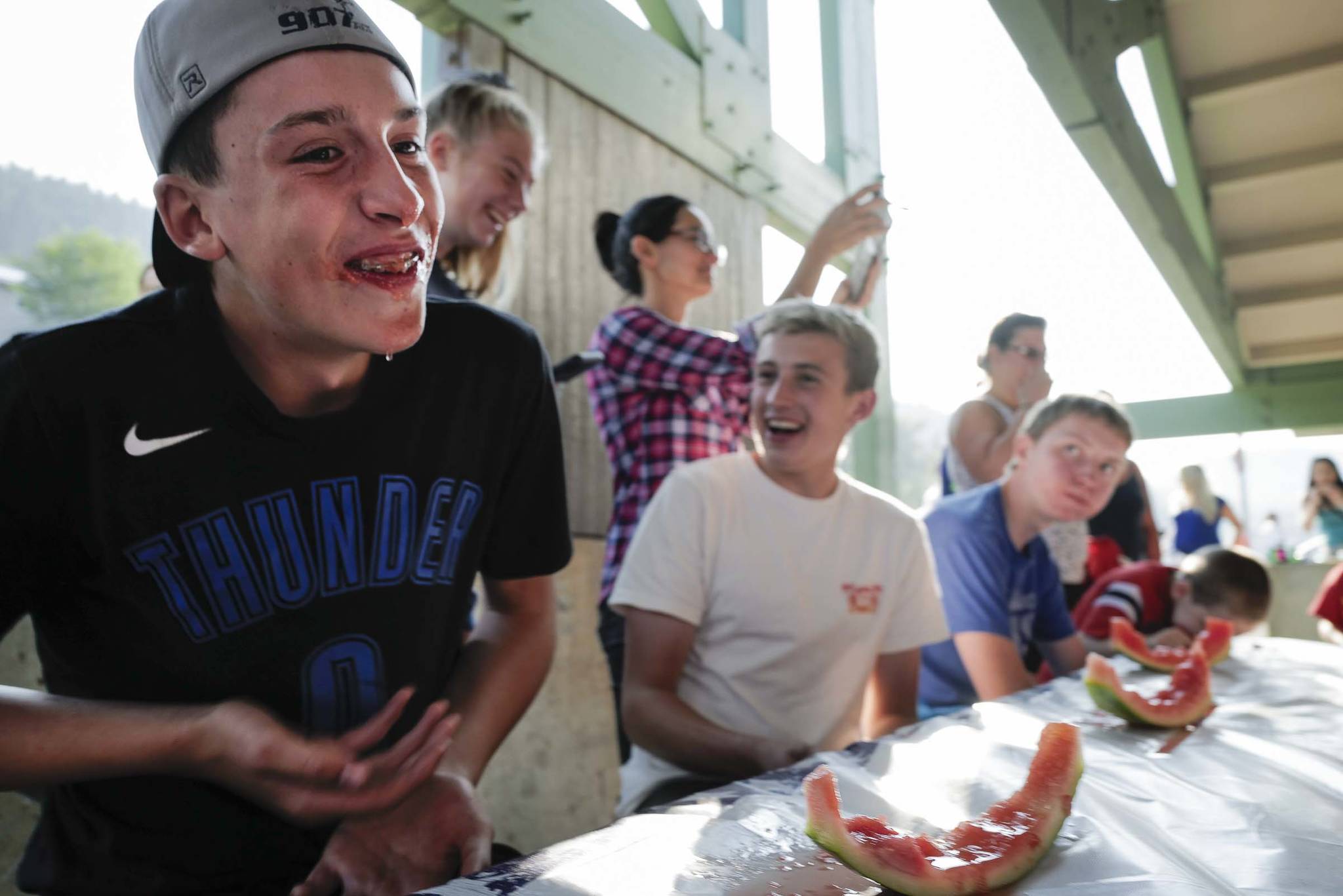 Kai Hargrave, 14, left, and his friend Chaz Van Slyke,14, laugh after participating in a watermelon eating contest during a community picnic sponsored by the Douglas Fourth of July Committee and Capital City Fire/Rescue at Sandy Beach on Wednesday, July 3, 2019. (Michael Penn | Juneau Empire)