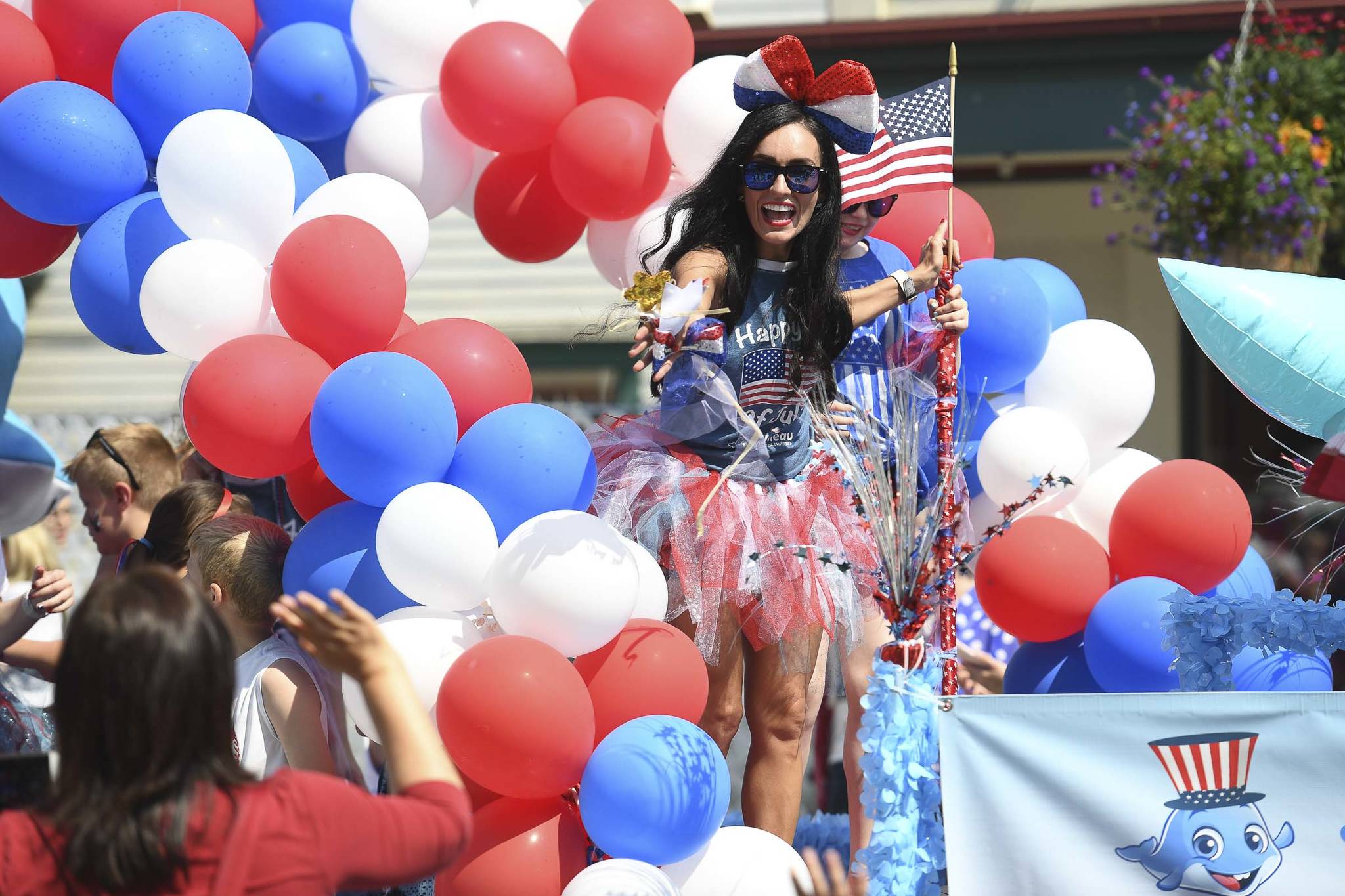 Dr. Jessy Blanco waves from her Juneau Pediatric Dentistry float during the Juneau Fourth of July Parade on Thursday, July 4, 2019. (Michael Penn | Juneau Empire)