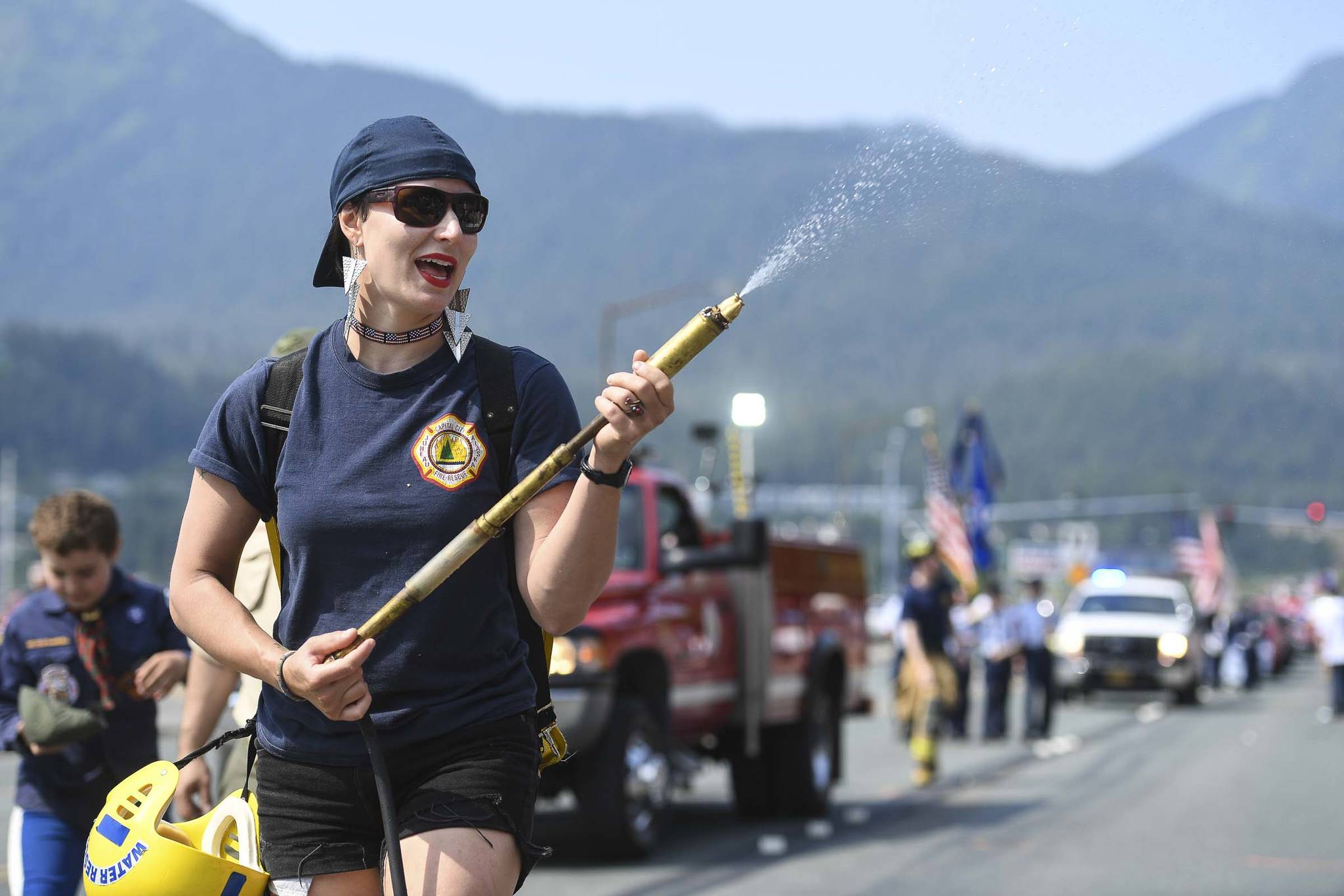 Meghan DeSloover of Capital City Fire/Rescue keeps poeple cool during the Juneau Fourth of July Parade on Thursday, July 4, 2019. (Michael Penn | Juneau Empire)
