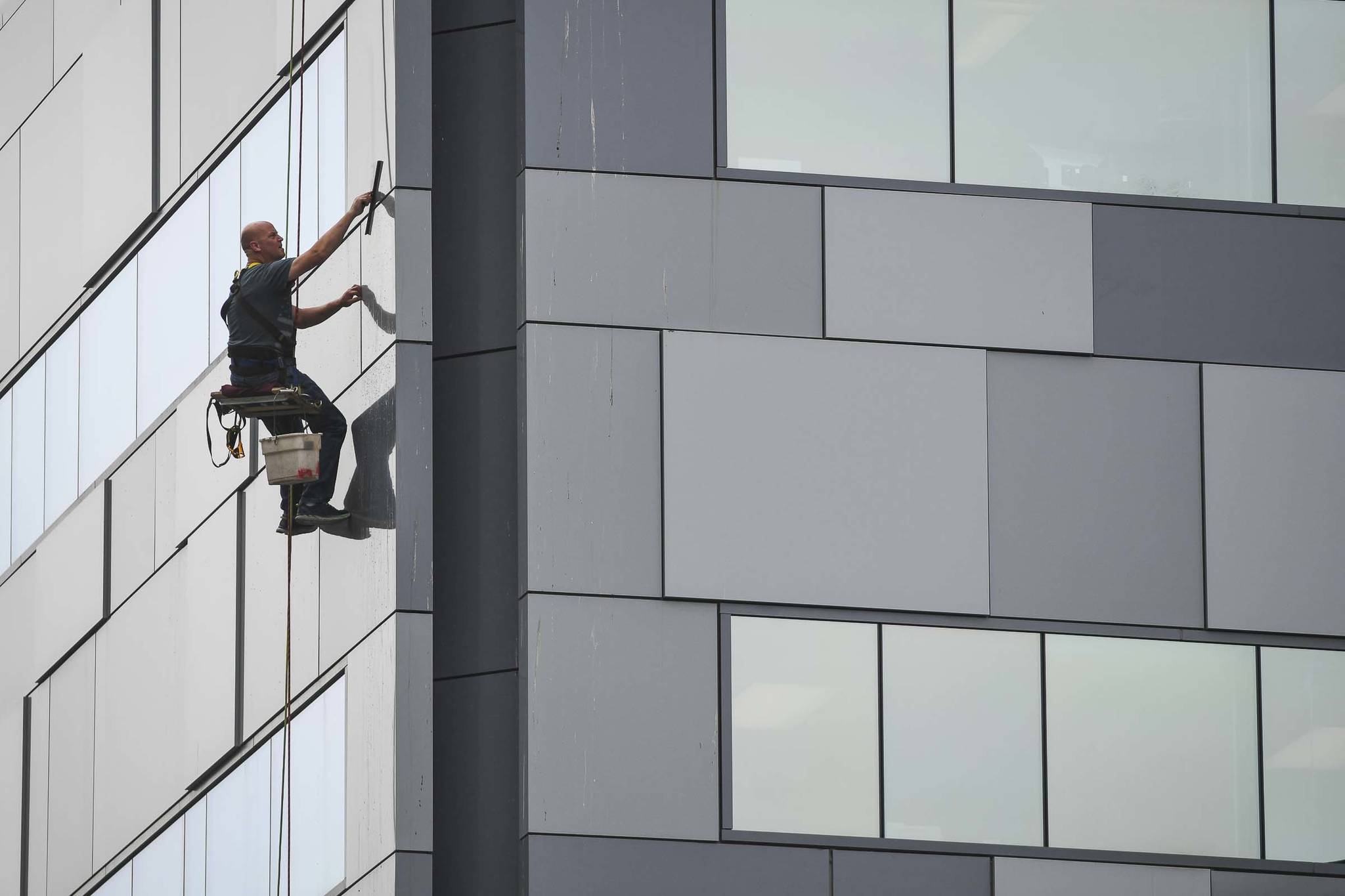 Andy Engstrom cleans the windows and siding of the Court Plaza Building on Friday, July 26, 2019. (Michael Penn | Juneau Empire)