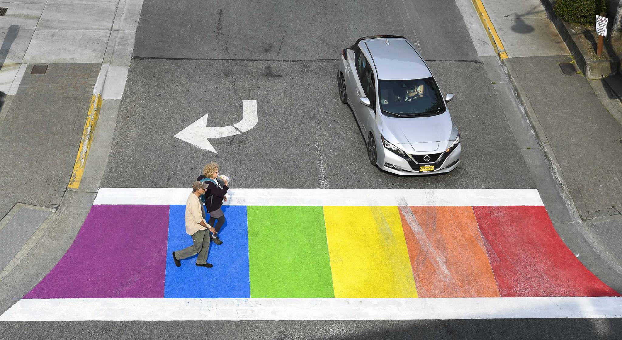 Pedestrians cross Front Street at Main after the city finished painting the crosswalk in rainbow colors on Friday, Aug. 2, 2019. (Michael Penn | Juneau Empire)
