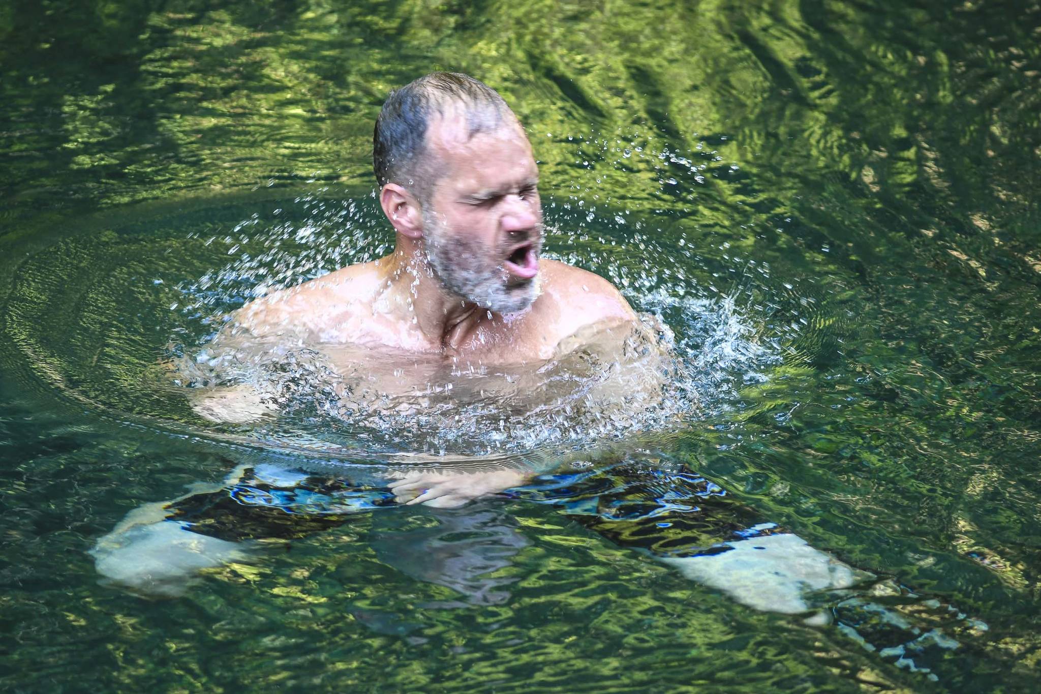Iver Nore shakes the water off his face as he takes a swim in Gold Creek on Friday, Aug. 2019. Temperatures are expected to hit their high’s in the 70’s through Monday. (Michael Penn | Juneau Empire)
