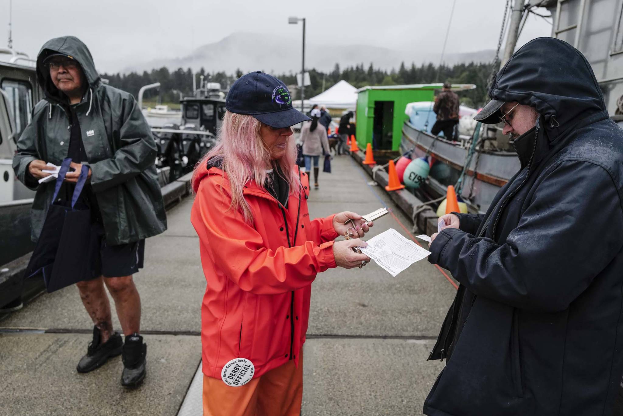 Derby Official Cheri Wharton validates Jeremy Dunn’s ticket at the Don D. Statter Boat Harbor in Auke Bay at the start of the Golden North Salmon Derby on Friday, Aug. 23, 2019. (Michael Penn | Juneau Empire)