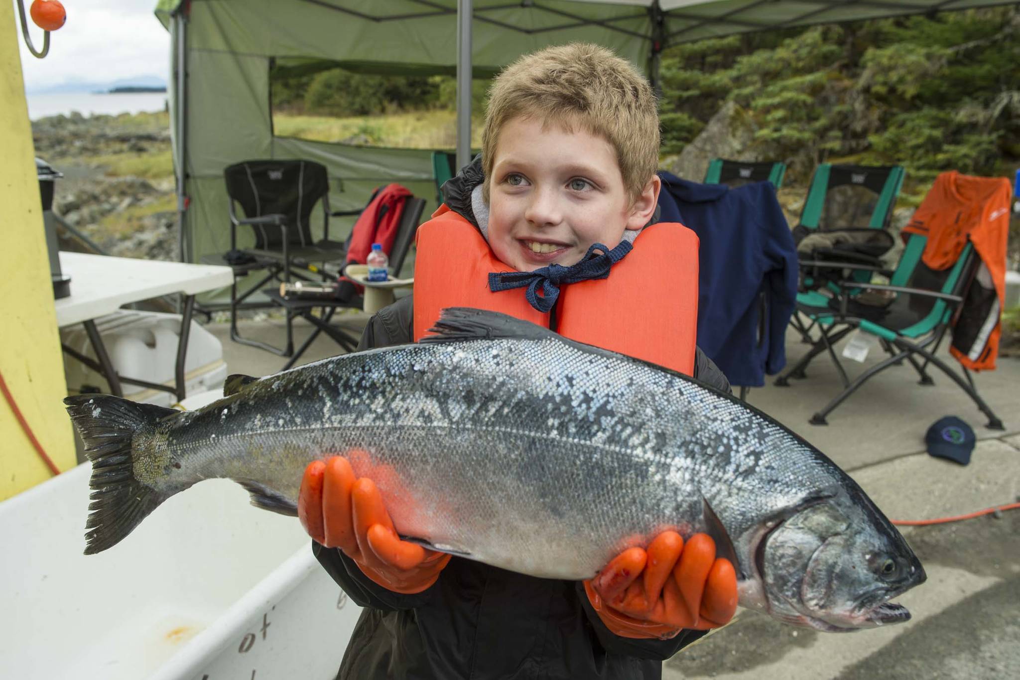 Tito Ritter, 9, holds an 8.5 pound coho he turned in at the Golden North Salmon Derby’s station at Amalga Harbor on Saturday, Aug. 24, 2019. (Michael Penn | Juneau Empire)