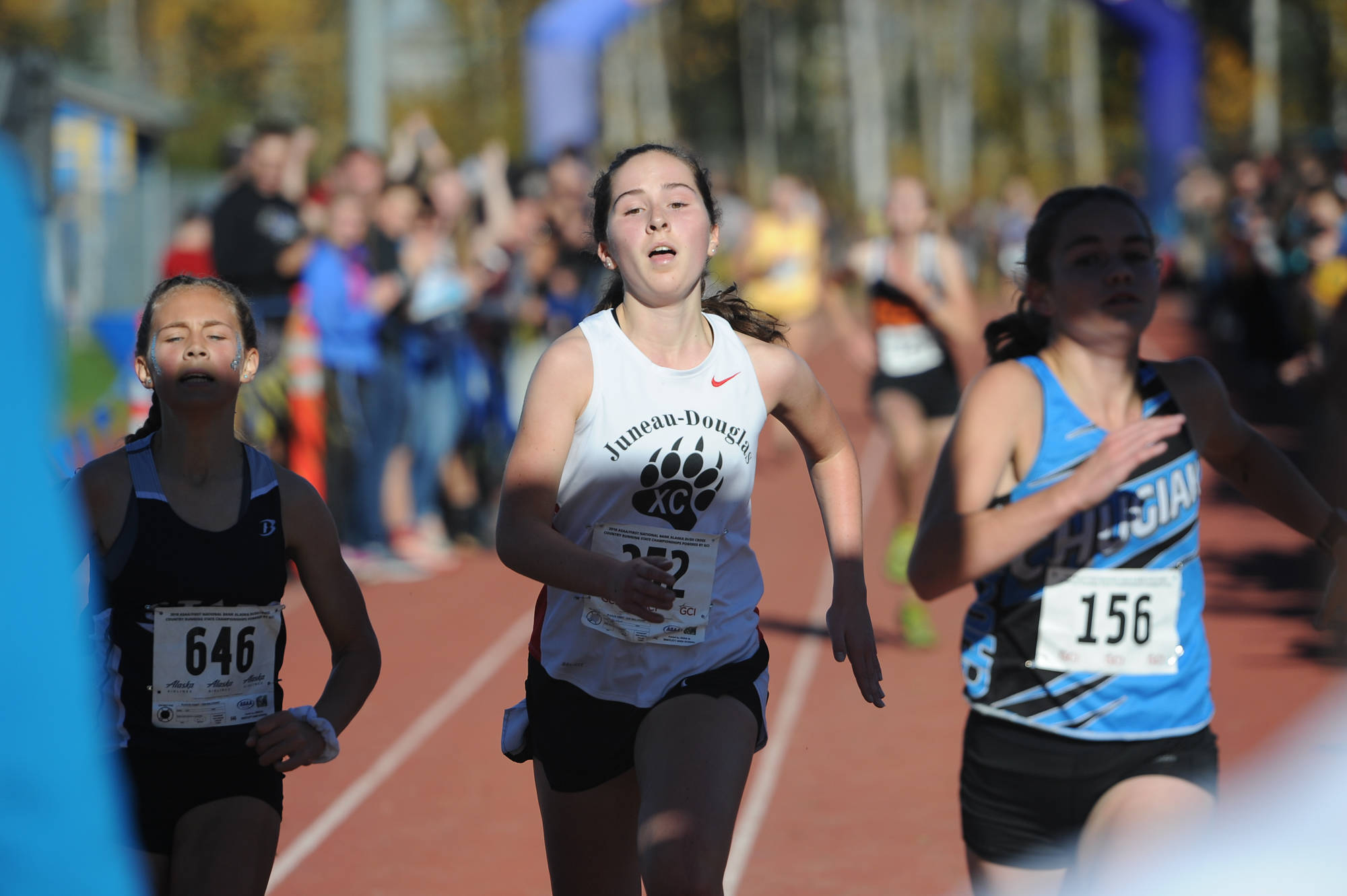 Juneau-Douglas High School: Yadaat.at Kalé’s Katie McKenna finishes in 17th place in the 2018 ASAA Division I state cross country championships next to Soldotna’s Jordan Strausbaugh, left, and Chugiak’s Breanna Day at Bartlett High School in Anchorage on Saturday, Sept. 28, 2018. (Michael Dinneen | For the Juneau Empire)