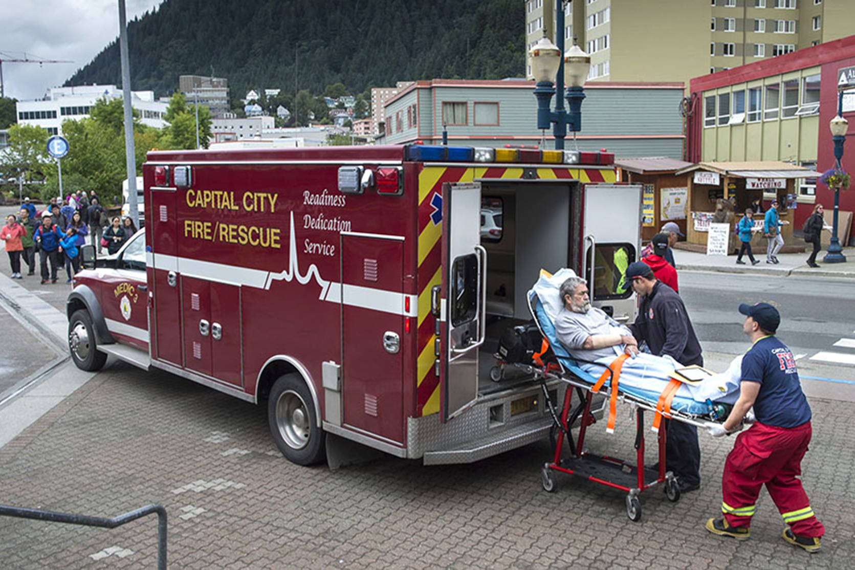 A Capital City Fire/Rescue crew transports a cruise ship passenger off the Radiances of the Seas downtown on Tuesday, August 14, 2018. (Michael Penn | Juneau Empire)