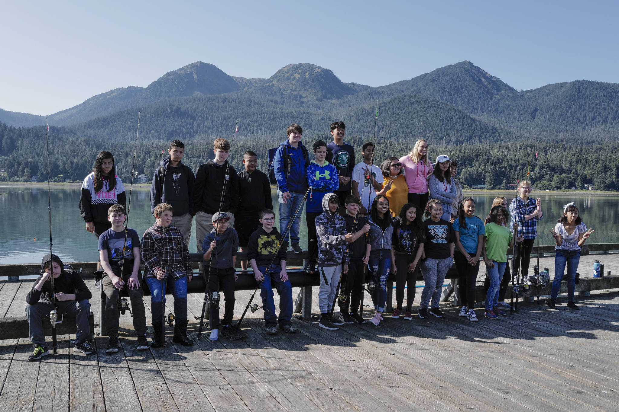 Eight-graders from Dzantik’i Heeni Middle School pose for a pictures after fishing for salmon at the Wayside Park on Channel Drive on Friday, Aug. 30, 2019. The fish will be used in a dog treat business the students are developing to raise money for a water filtering system to be used at the school. Two math teachers, Bobby Jones and Tennie Bentz, are having the students start four businesses as a way of teaching the use of math in the real world. (Michael Penn | Juneau Empire)
