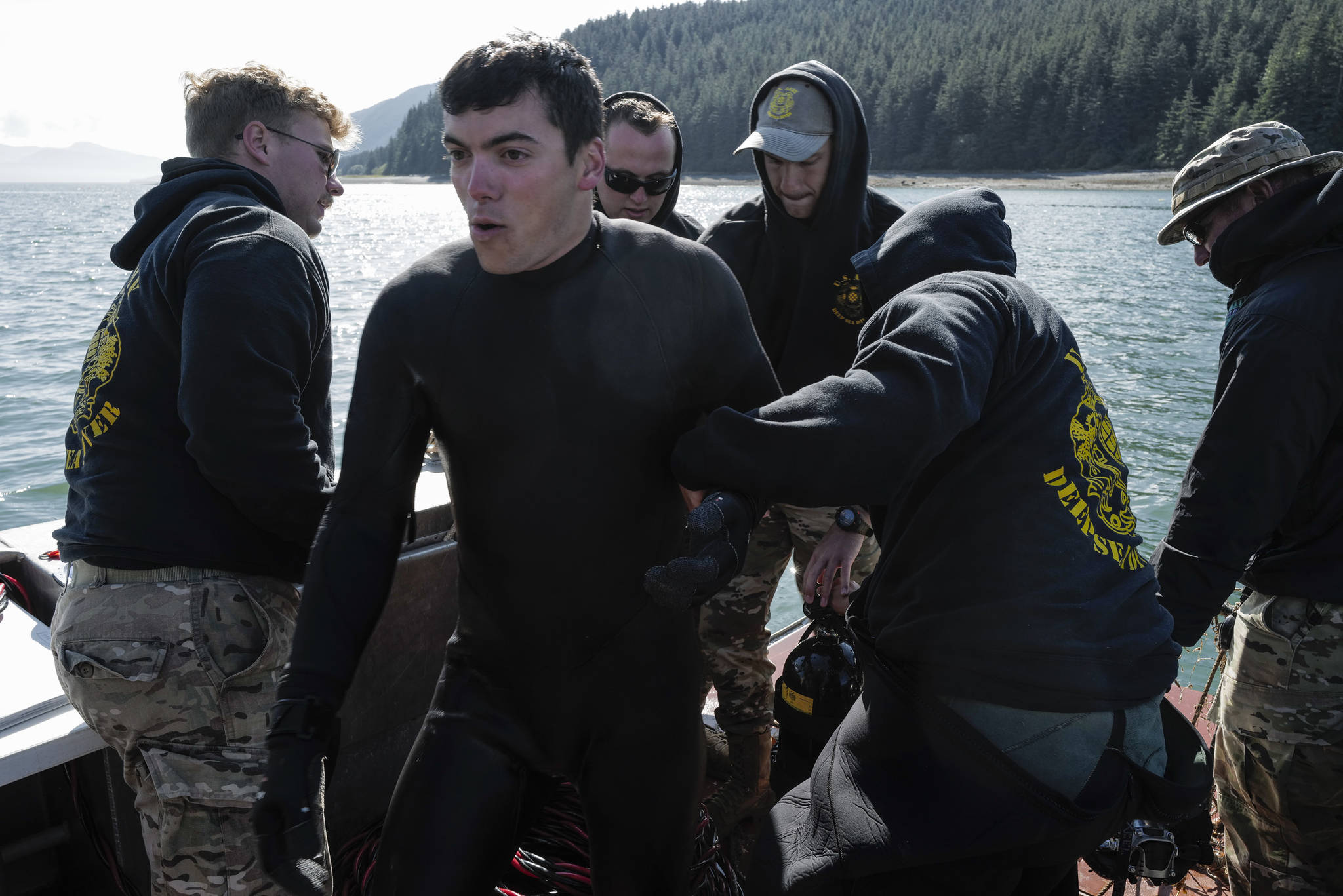 Spc. James Lewis, center, is helped out of his diving gear by teammates of the Army’s 74th Engineer Dive Detachment after retrieving a lost crab pots in 100 feet of water in Gastineau Channel for the Douglas Indian Association/NOAA Marine Debris Project on Thursday, Sept. 5, 2019. The project aims to identify and remove derelict crab pots and their continued negative impact on wildlife and the environment. (Michael Penn | Juneau Empire)