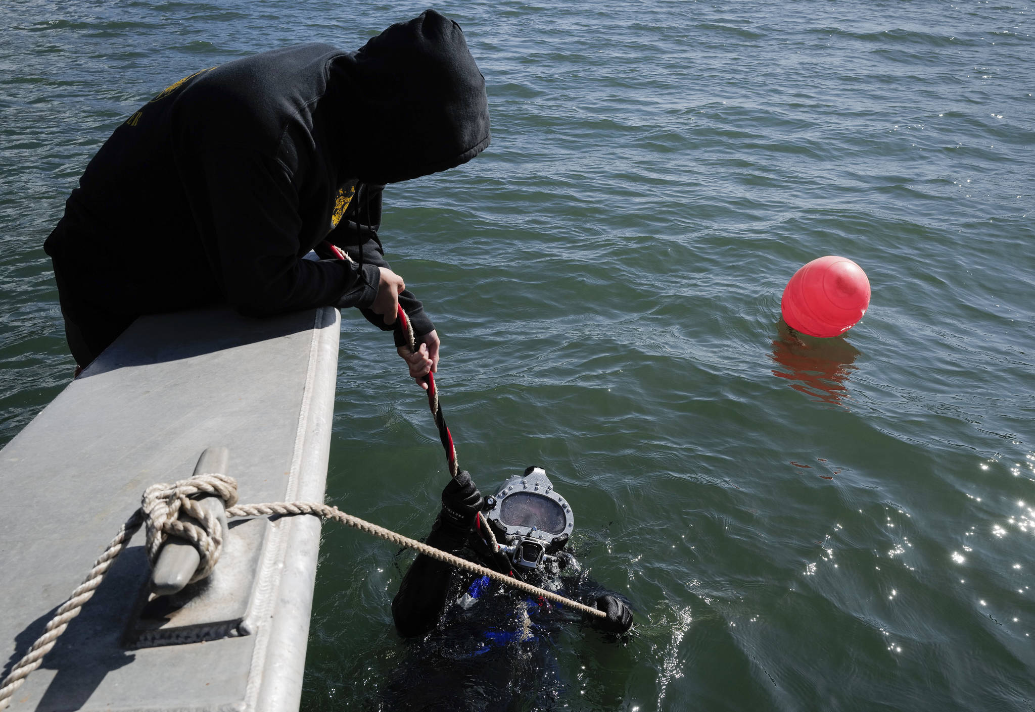 Members of the Army’s 74th Engineer Dive Detachment work off a Juneau Harbormaster boat to retrieve lost crab pots in Gastineau Channel for the Douglas Indian Association/NOAA Marine Debris Project on Thursday, Sept. 5, 2019. The project aims to identify and remove derelict crab pots and their continued negative impact on wildlife and the environment. (Michael Penn | Juneau Empire)