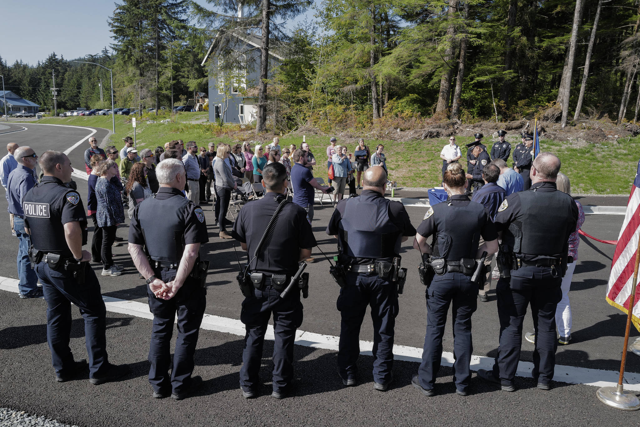 Juneau Police Department officers attend a ribbon-cutting ceremony with others on Karl Reishus Boulevard to commemorate the near completion of the Pederson Hill Subdivision on Friday, Sept. 6, 2019. Reishus was a Juneau Police Department officer who died in 1992 when he fell from a 40-foot tower during a training exercise. (Michael Penn | Juneau Empire)