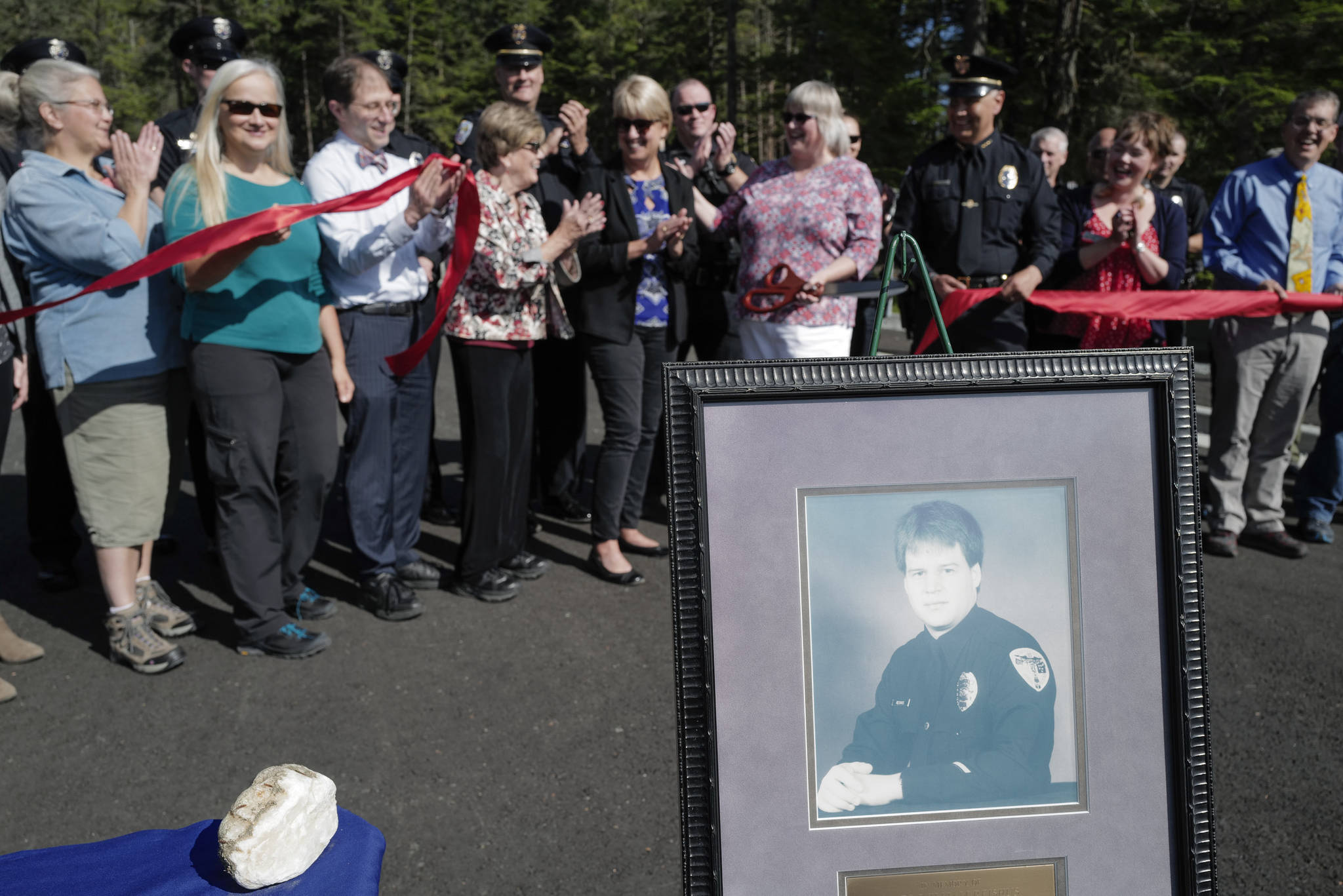 City and state officials attend a ribbon-cutting ceremony on Karl Reishus Boulevard to commemorate the near completion of the Pederson Hill Subdivision on Friday, Sept. 6, 2019. Reishus, pictured, was a Juneau Police Department officer who died in 1992 when he fell from a 40-foot tower during a training exercise. (Michael Penn | Juneau Empire)