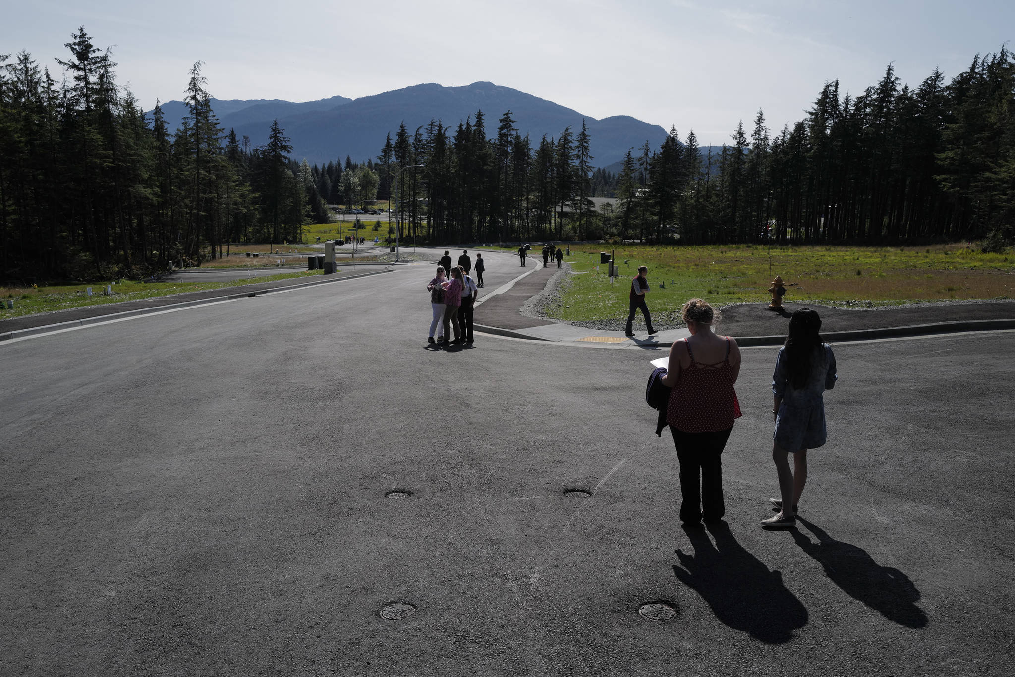 People walk along Karl Reishus Boulevard after a ribbon-cutting ceremony to commemorate the near completion of the Pederson Hill Subdivision on Friday, Sept. 6, 2019. Reishus was a Juneau Police Department officer who died in 1992 when he fell from a 40-foot tower during a training exercise. (Michael Penn | Juneau Empire)