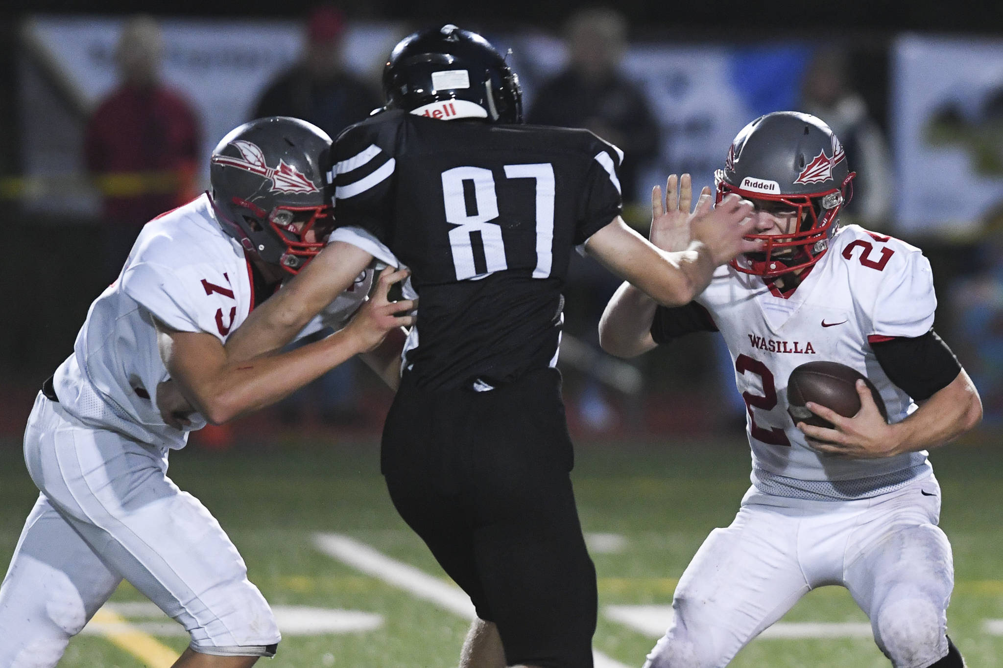 Juneau’s Cole Jensen, center, moves to sack Wasilla quarterback Colton Lindquist, right, despite blocking by Wasilla’s Andrew Devine in the second quarter at Adair-Kennedy Memorial Field on Friday, Sept. 6, 2019. Juneau won 63-0. (Michael Penn | Juneau Empire)