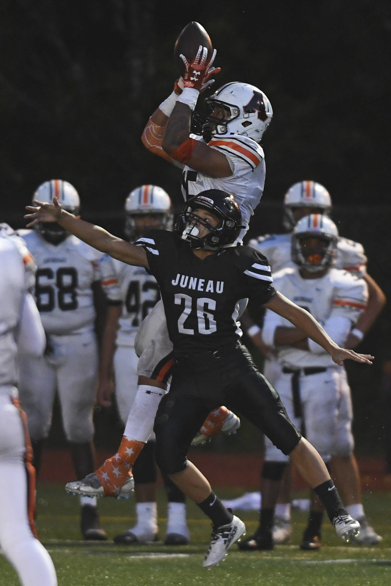 West’s Dhar Montalbo catches a pass over Juneau’s Jamal Johnson in the first quarter at Adair-Kennedy Memorial Field on Friday, Sept. 13, 2019. West won 43-14. (Michael Penn | Juneau Empire)