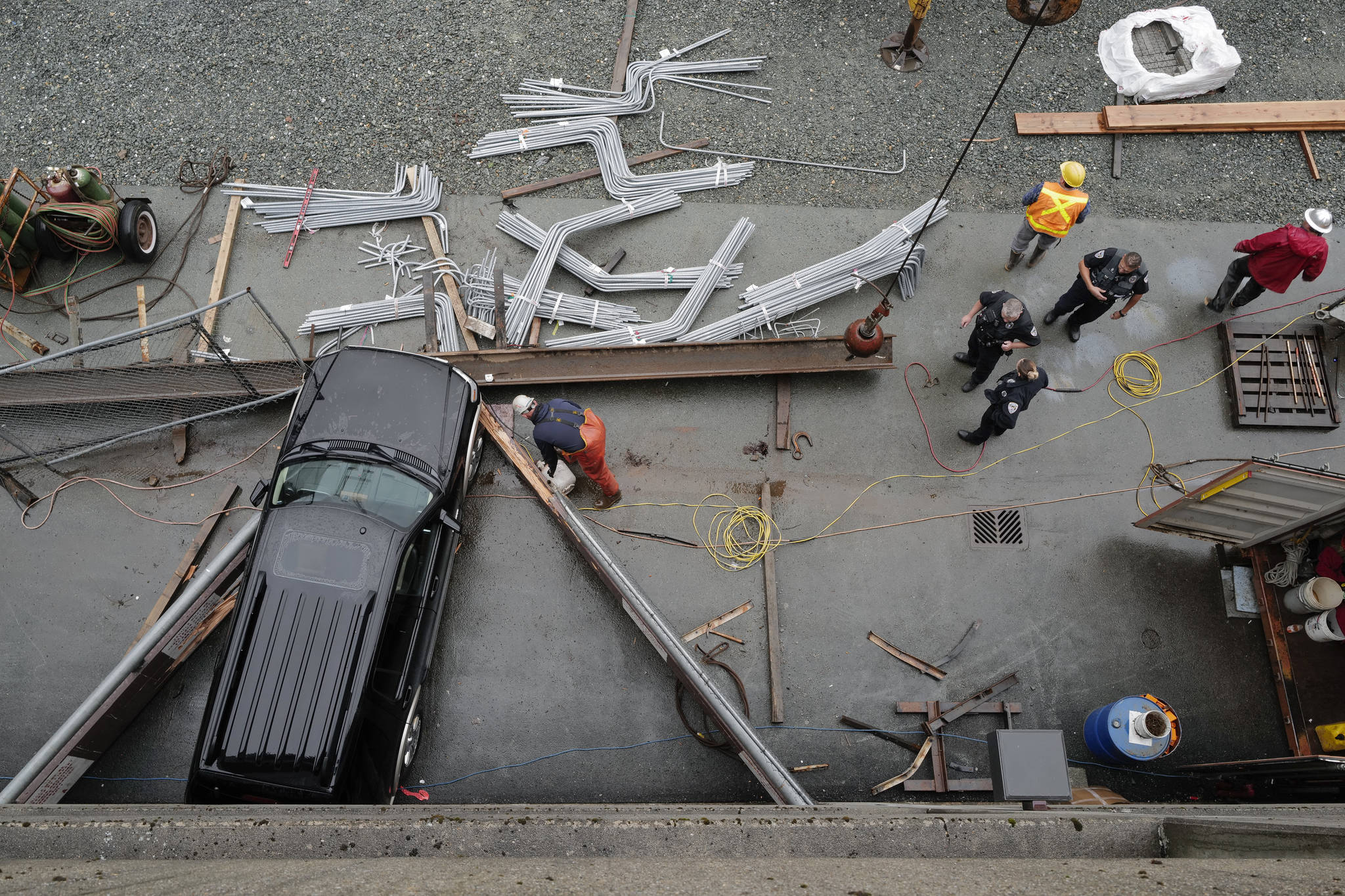 Juneau Police Department officers and Capital City Fire/Rescue personnel respond to an accident at the Downtown Public Library on Monday, Sept. 23, 2019. A construction worker was injured at a work site after a driver reportedly drove through the library parking barrier. (Michael Penn | Juneau Empire)