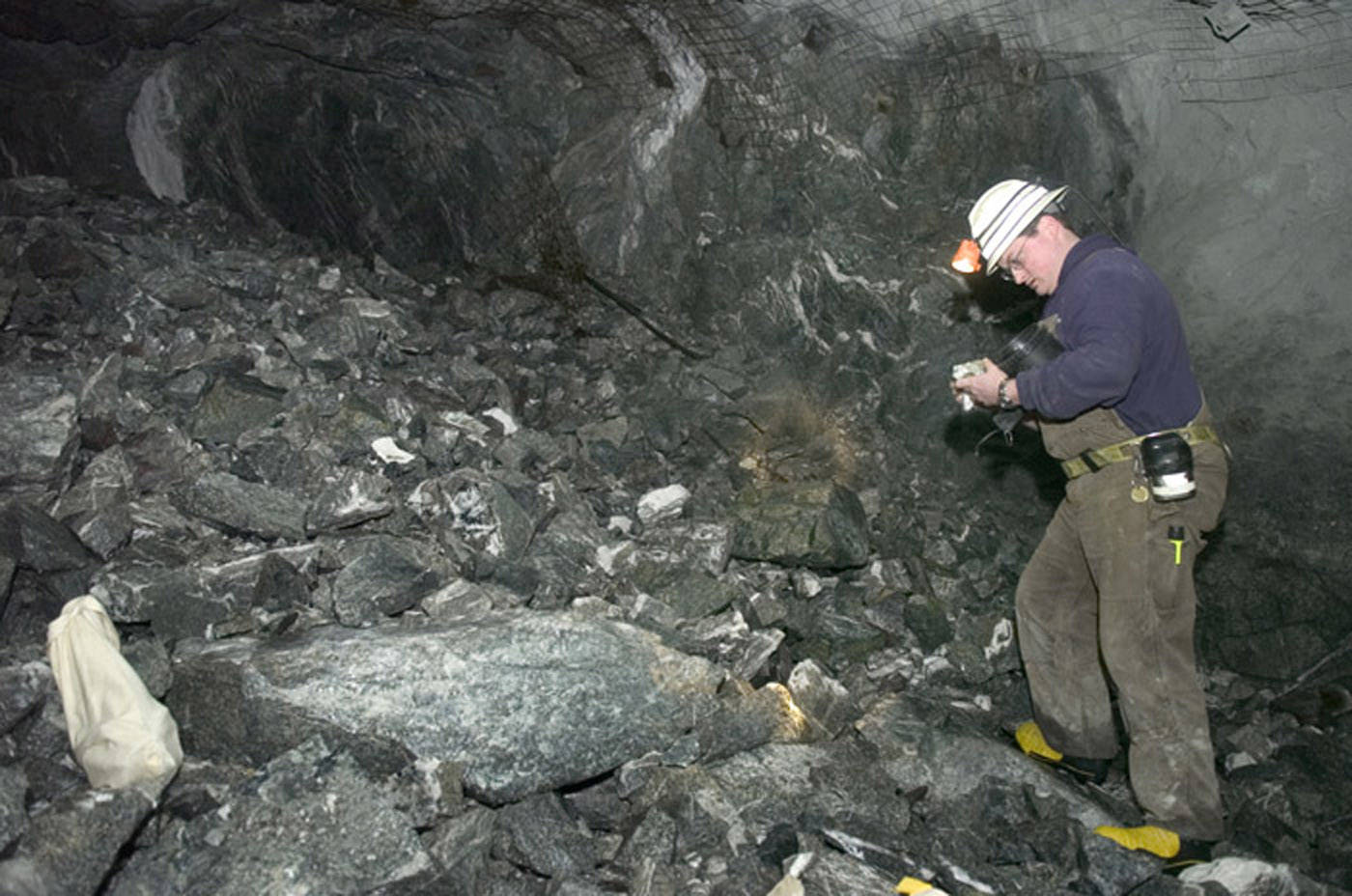 In this file photo from Feb. 2007, Kevin Torpy, Chief Engineer for Coeur Alaska, studies rock at a freshly blasted area in the tunnel coming from the Comet Mine side of the Kensington Mine project. (Juneau Empire File)