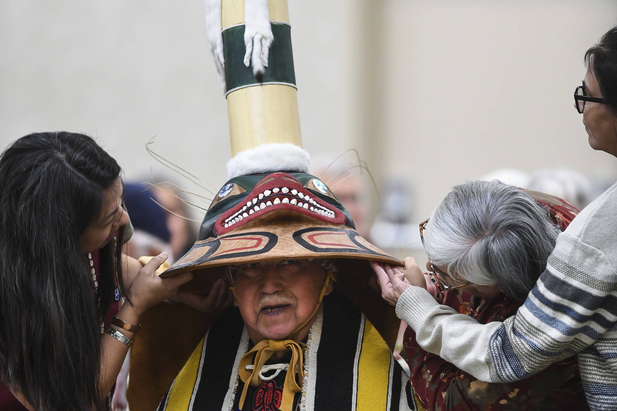 Members of the Killer Whale clan support a replica of a sculpin clan hat on Ray Wilson, clan leader for the Kiks.ádi Clan, during a welcoming ceremony at Elizabeth Peratrovich Hall on Wednesday, Sept. 25, 2019. The original hat was collected from the Kiks.ádi Clan in Sitka in 1884. The Smithsonian Institution used a 3D digitization process to document the hat and constructed the hat using traditional materials. (Michael Penn | Juneau Empire)